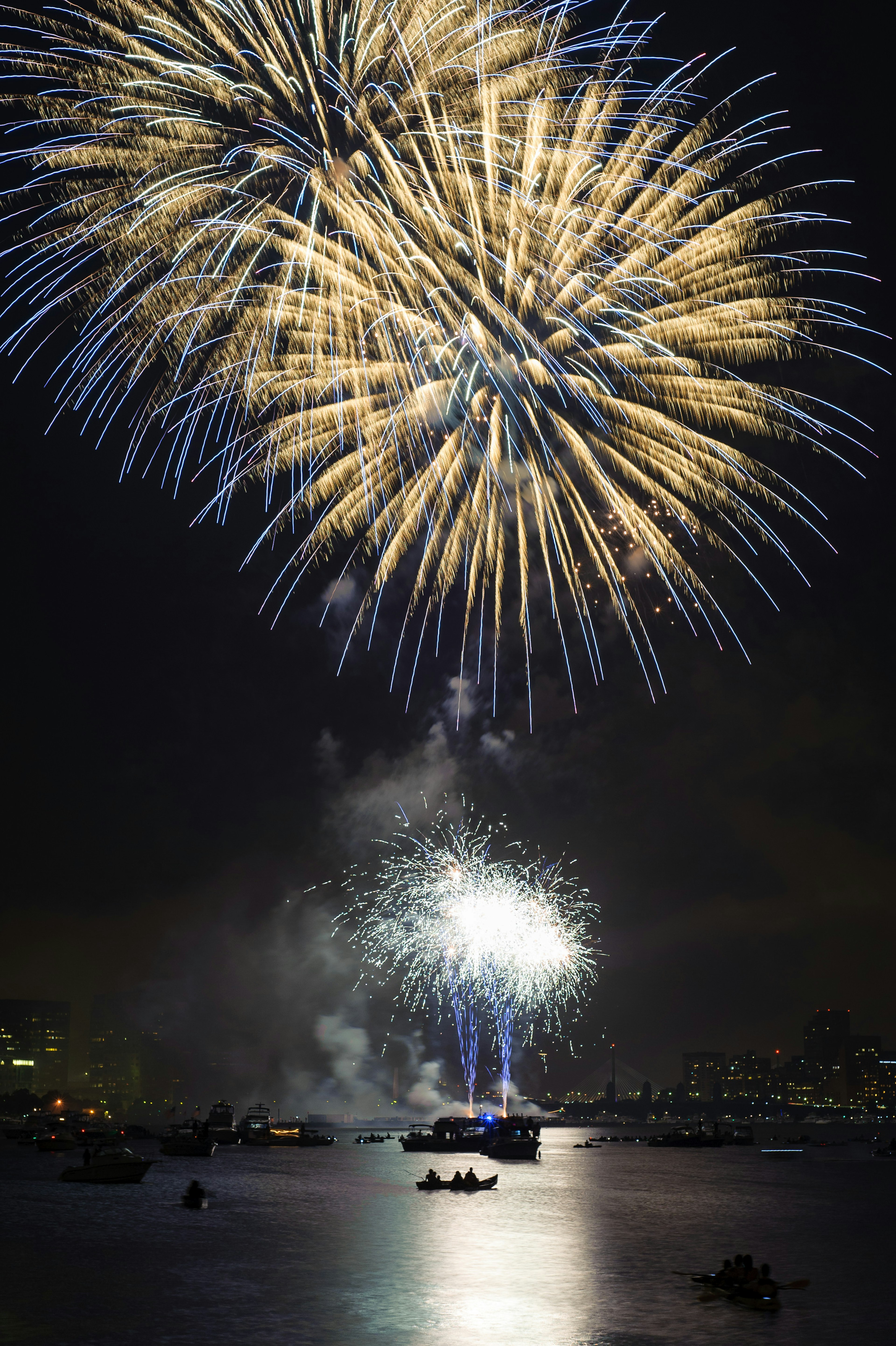 Fourth of July Fireworks 2012 in Boston over the Charles River with kayaks and boats in the water.