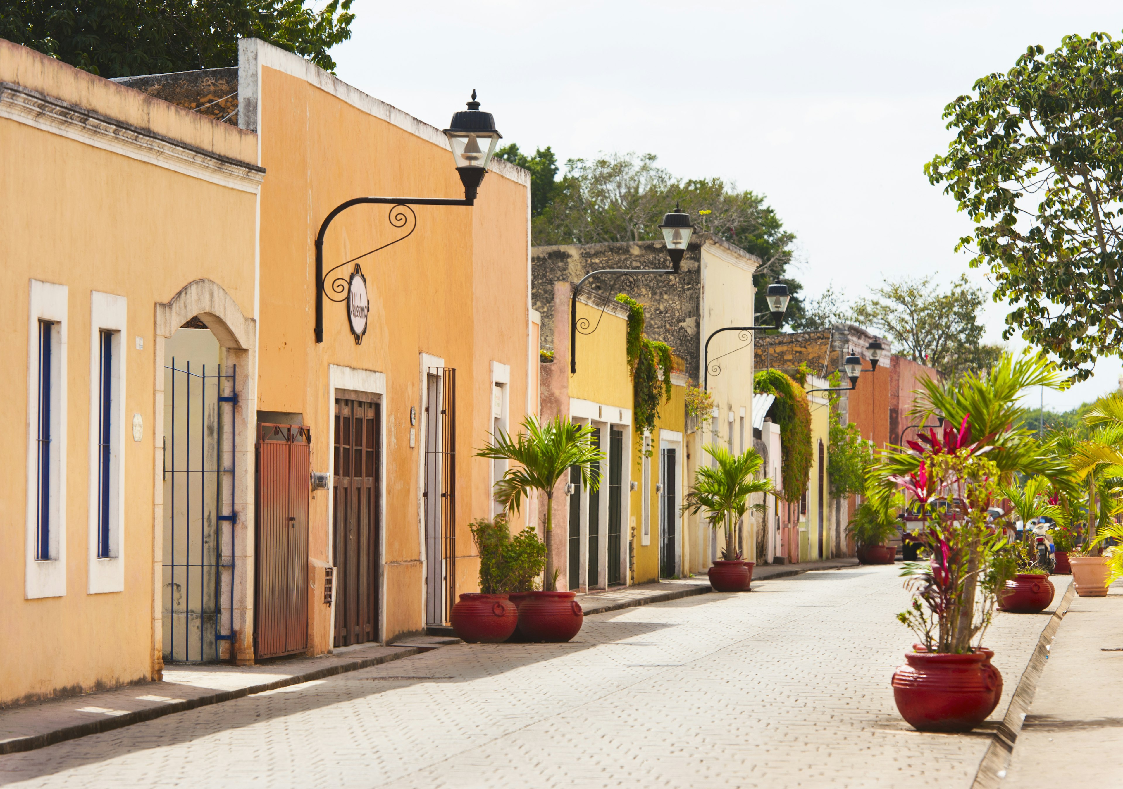 A row of terraced colonial-era houses painted in pale pastel yellows and oranges