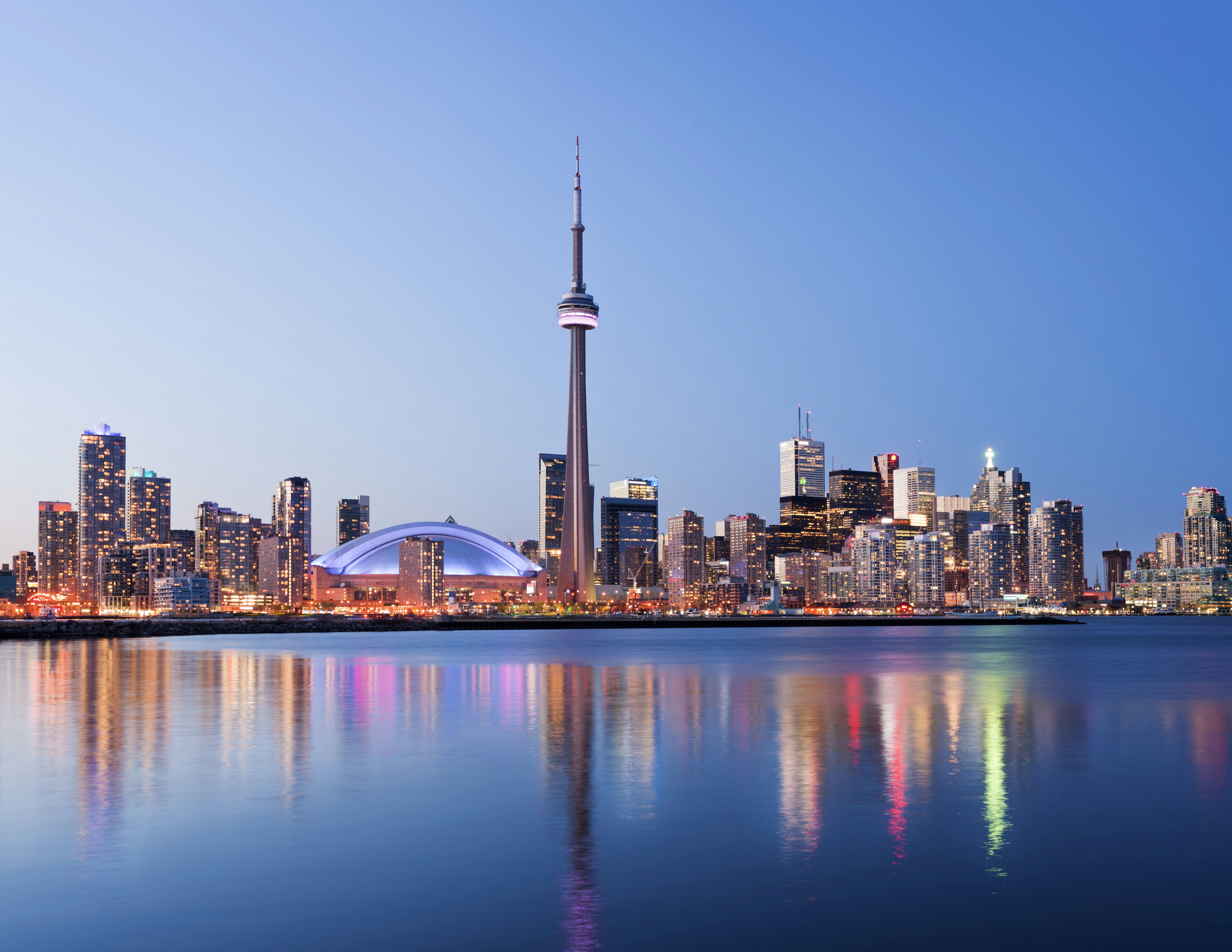 Toronto skyline at dusk, with the CN Tower against the sky.