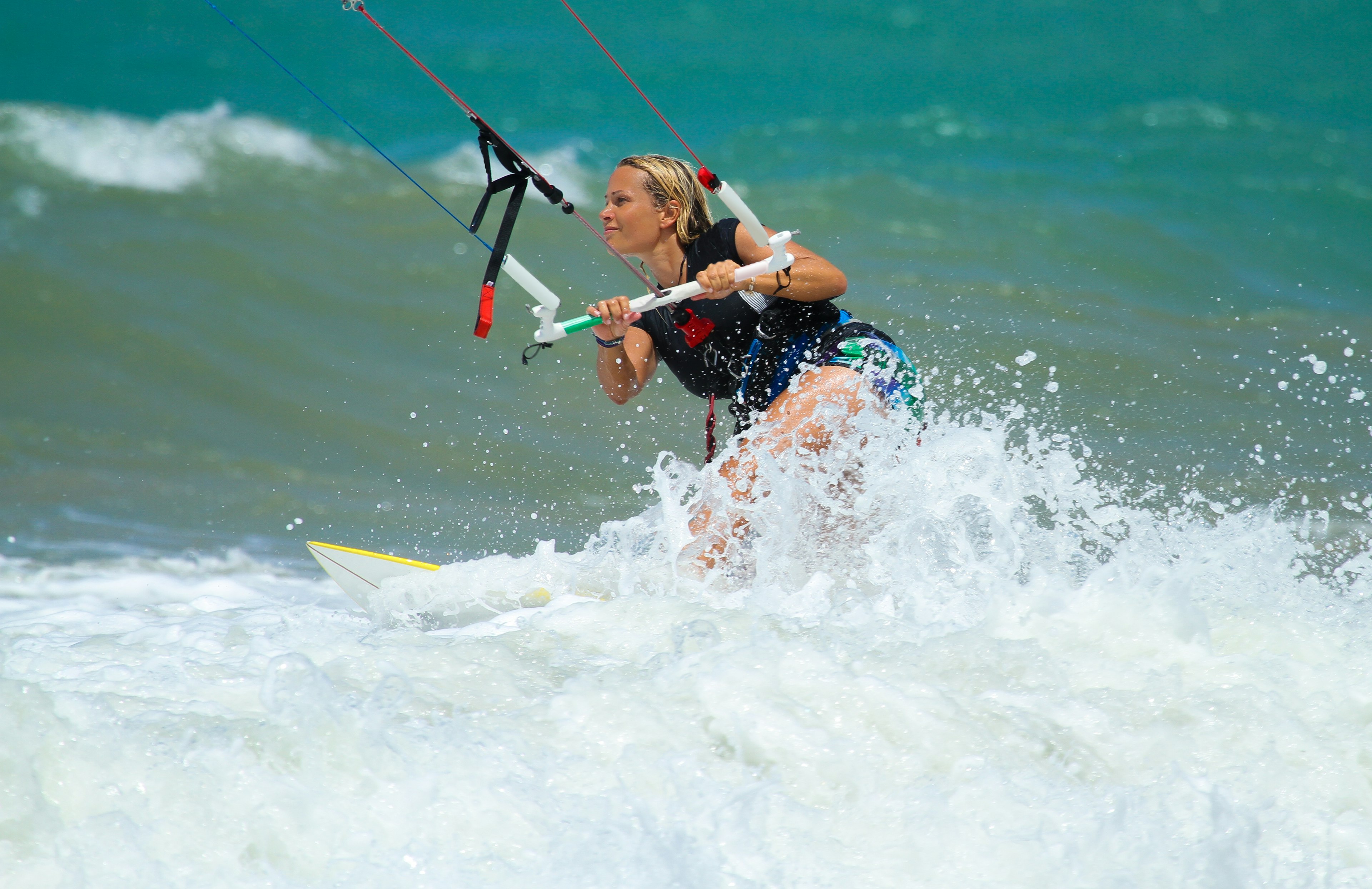 A closeup of a woman kiteboarding in the ocean