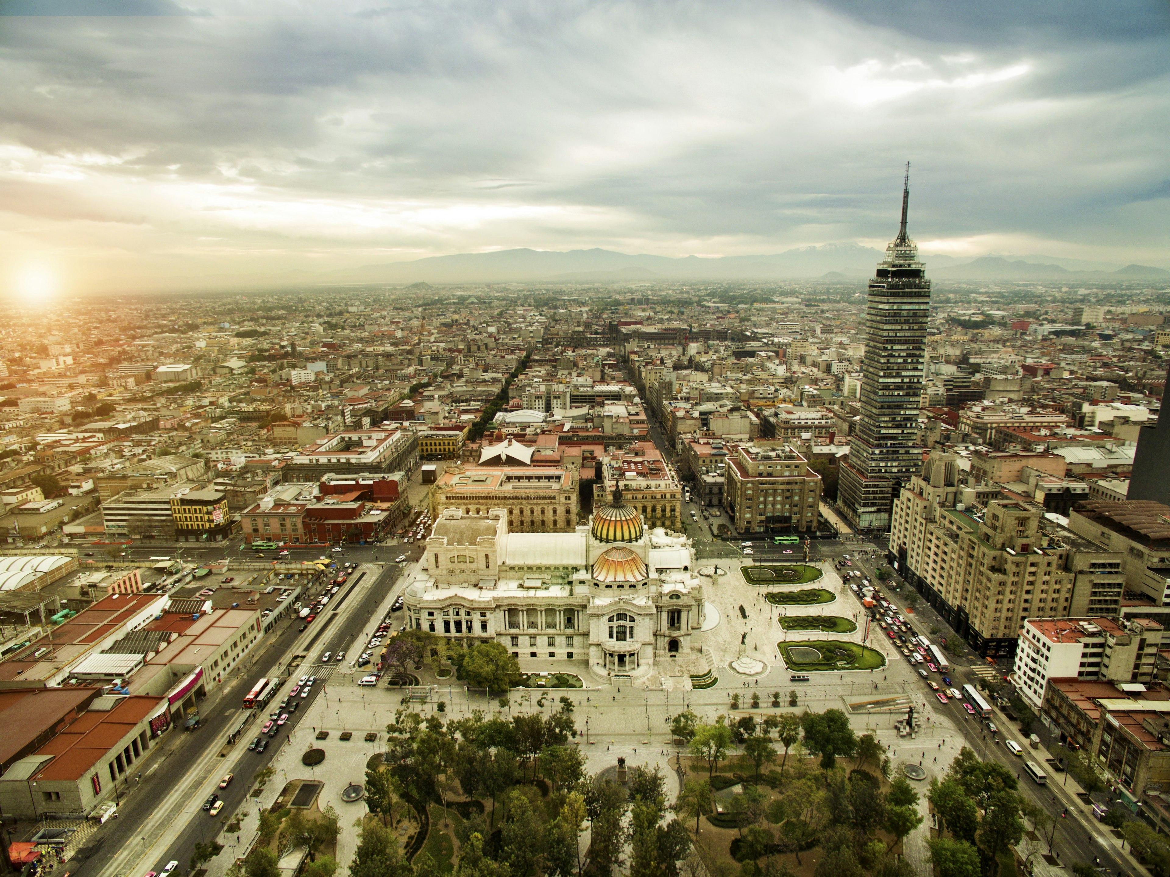 Aerial view of the Mexico City's grid layout, with a white domed building in the foreground, and a taller structure to the right