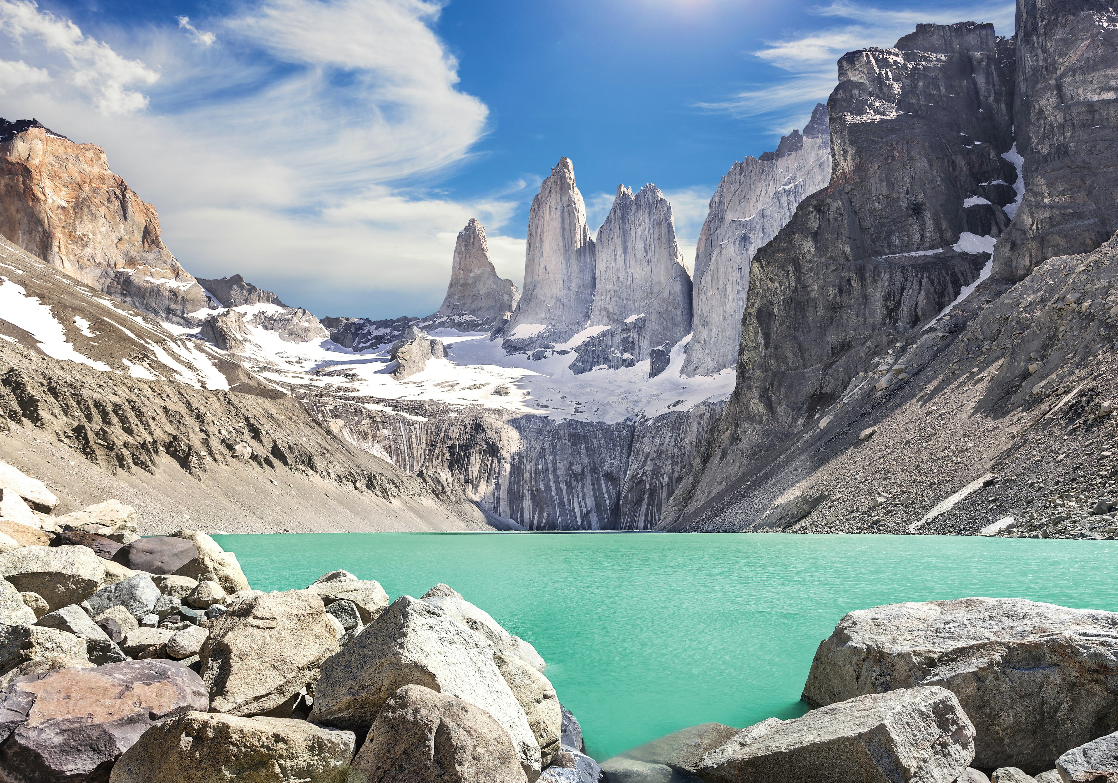 A dazzlingly blue lake surrounded by the gray peaks of the Torres del Paine mountains in Patagonia, Chile.