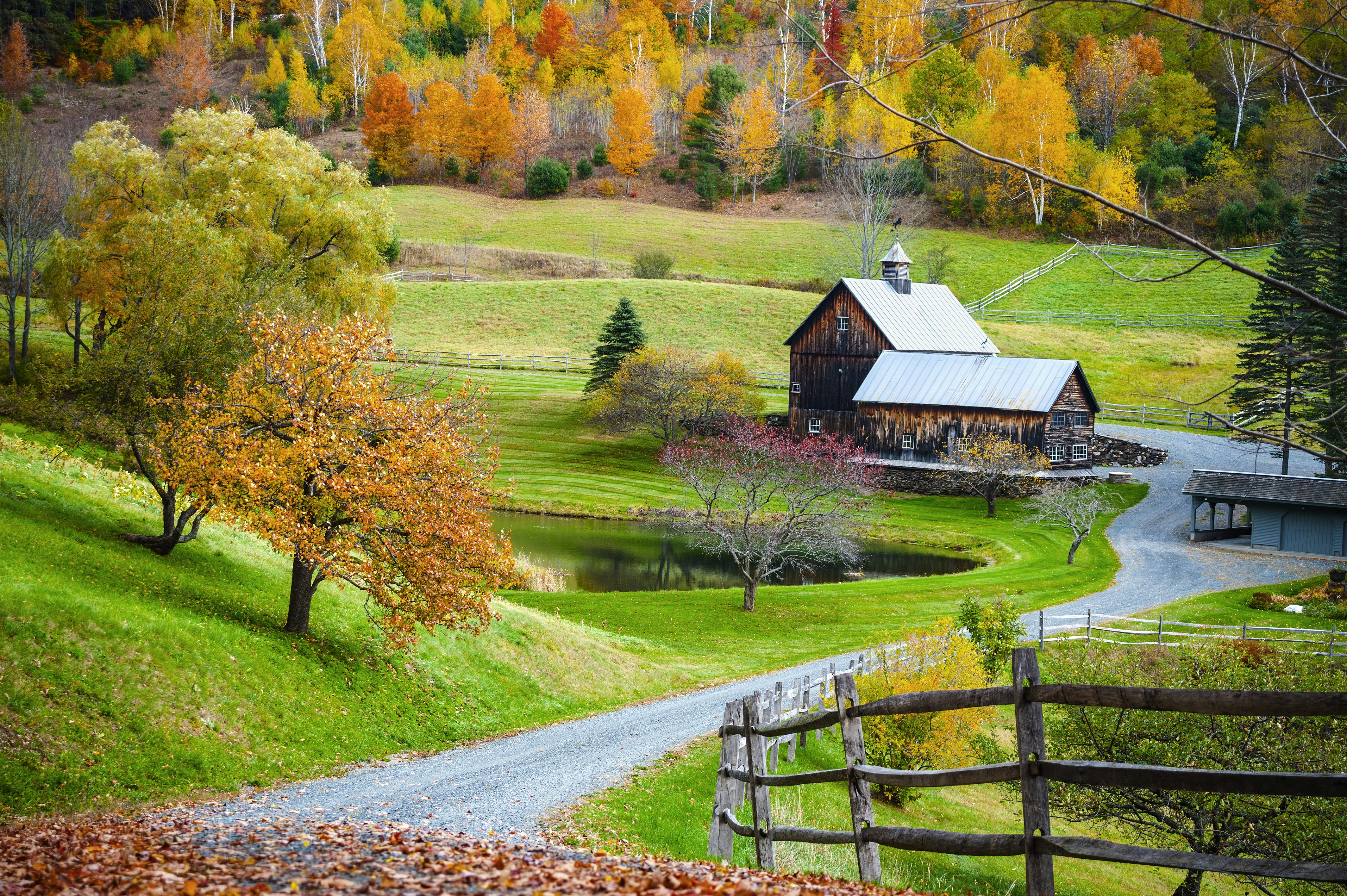 Old wooden barn surrounded by colorful trees, farm in autumn landscape