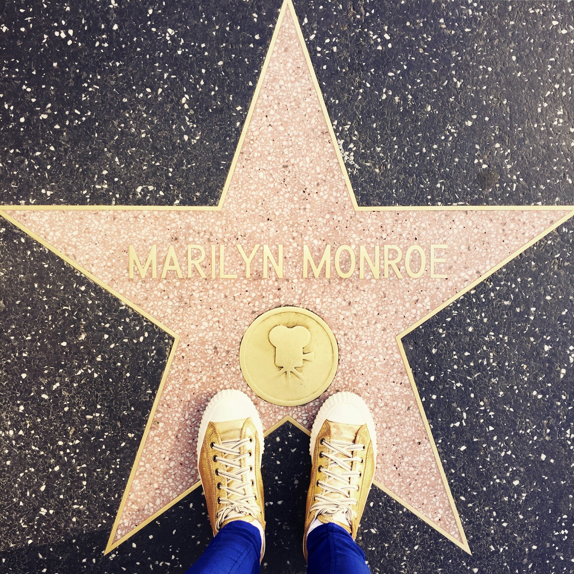 At the Walk of Fame in Hollywood - a girl standing with her All-Star's on the star of Marilyn Monroe for the photo.