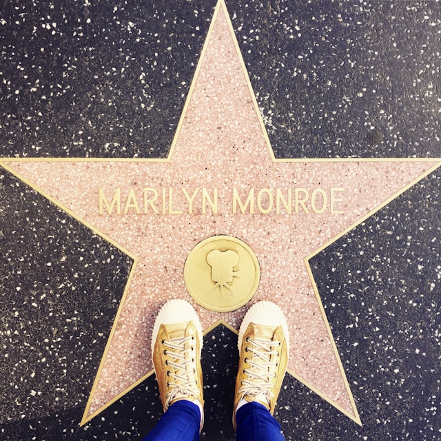 At the Walk of Fame in Hollywood - a girl standing with her All-Star's on the star of Marilyn Monroe for the photo.
