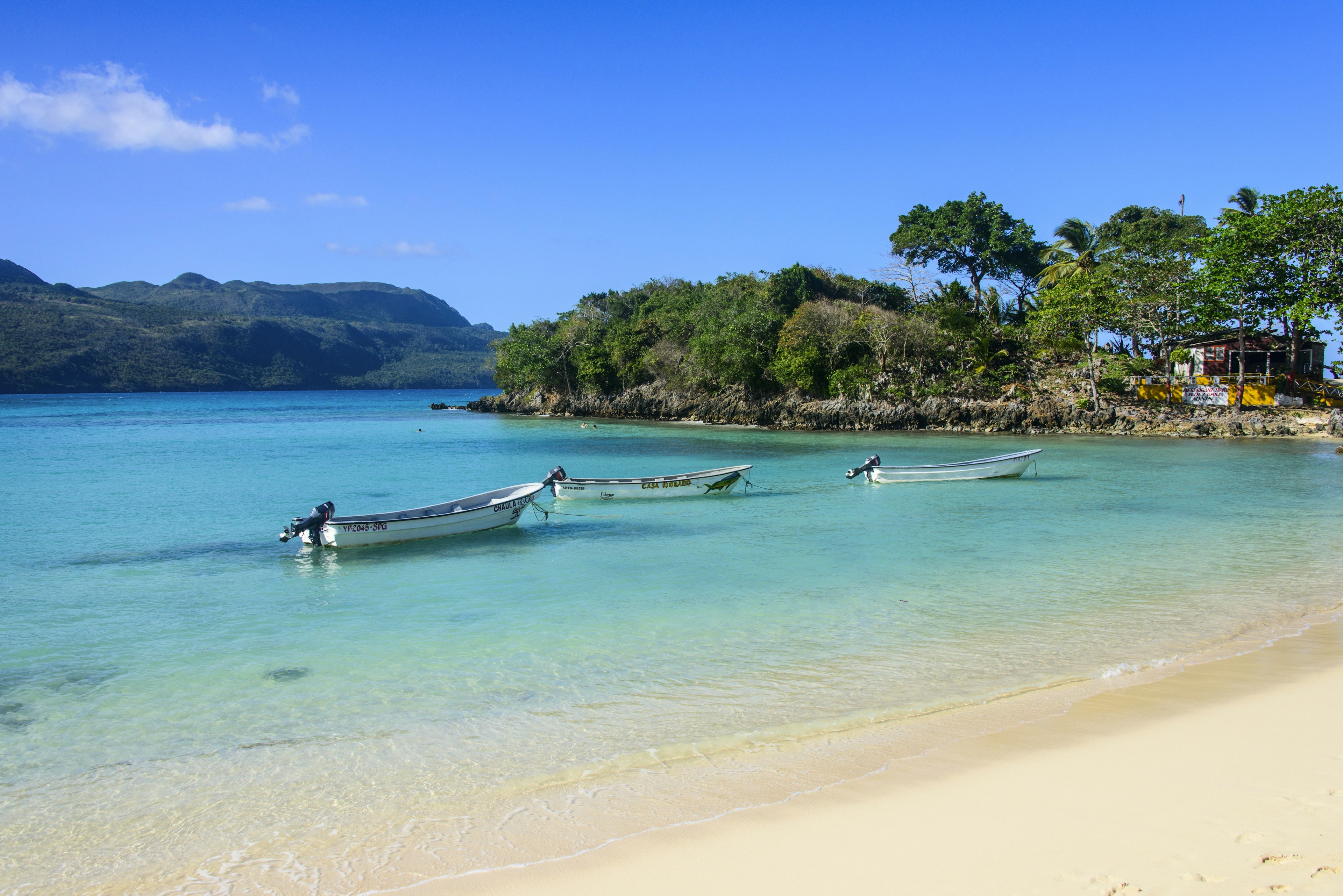 A trio of boats are moored in crystal clear waters at Playa Rincon