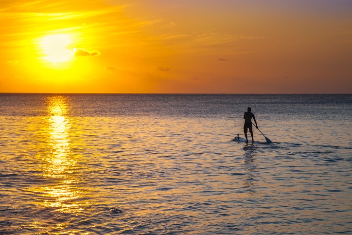 A standup paddleboarder at sunset, Conceicao Beach in Fernando de Noronha
