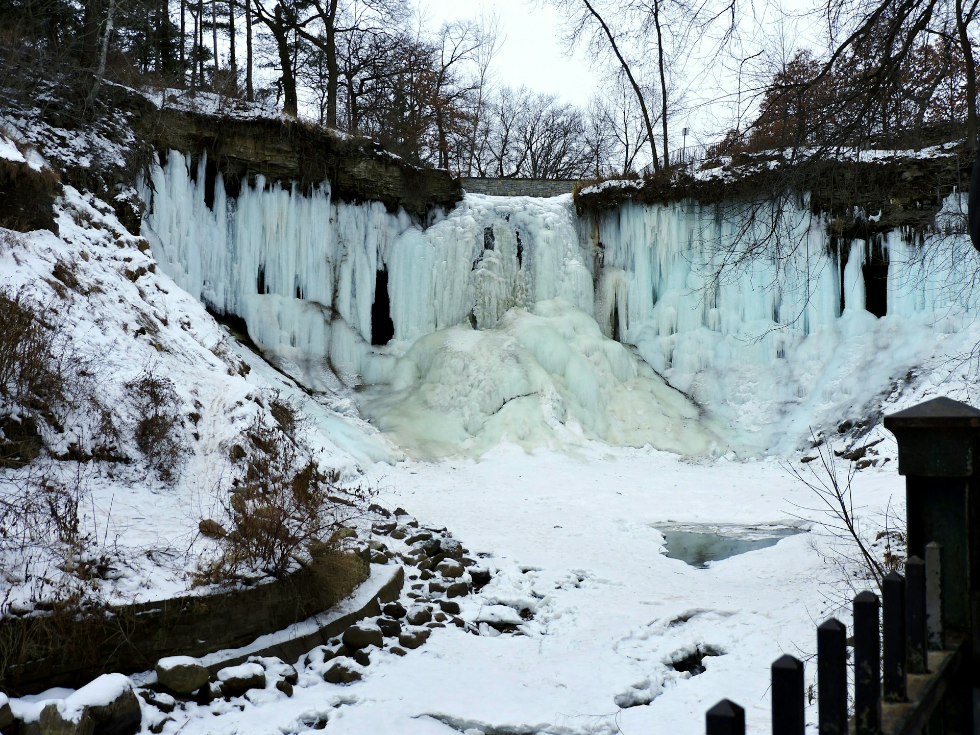 A frozen waterfall surrounded by snow