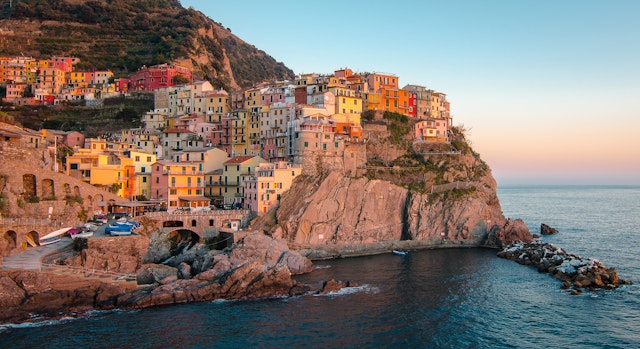 Colorful buildings on a cliffside at sunset in Manarola, Cinque Terre
