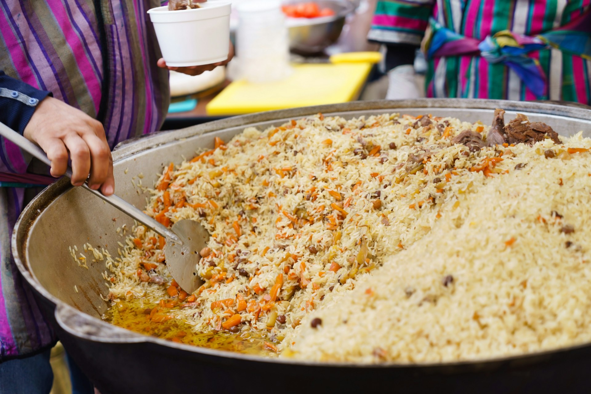 Woman stirring Plov the national dish of Uzbekistan