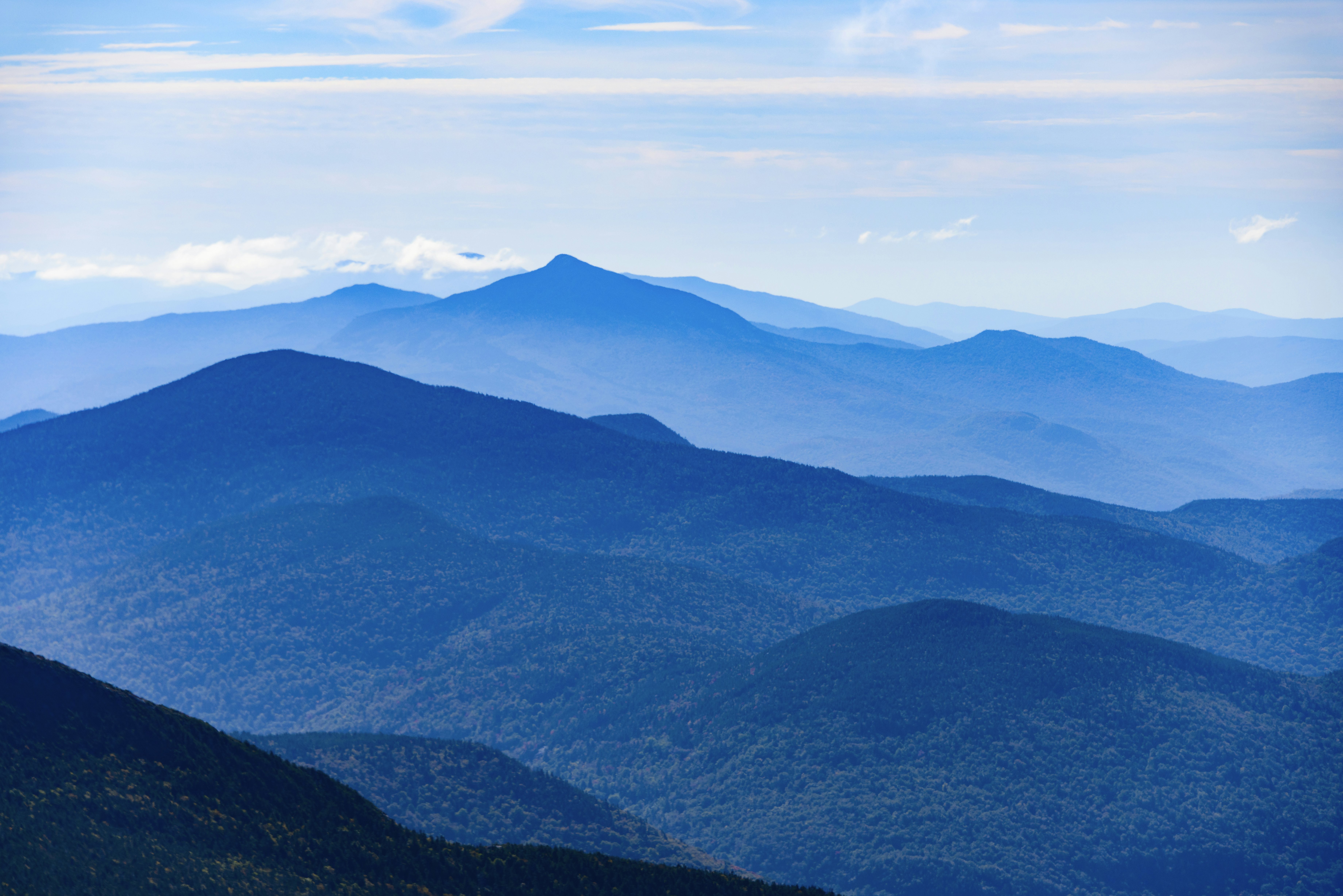 A mountain range in shades of green and blue