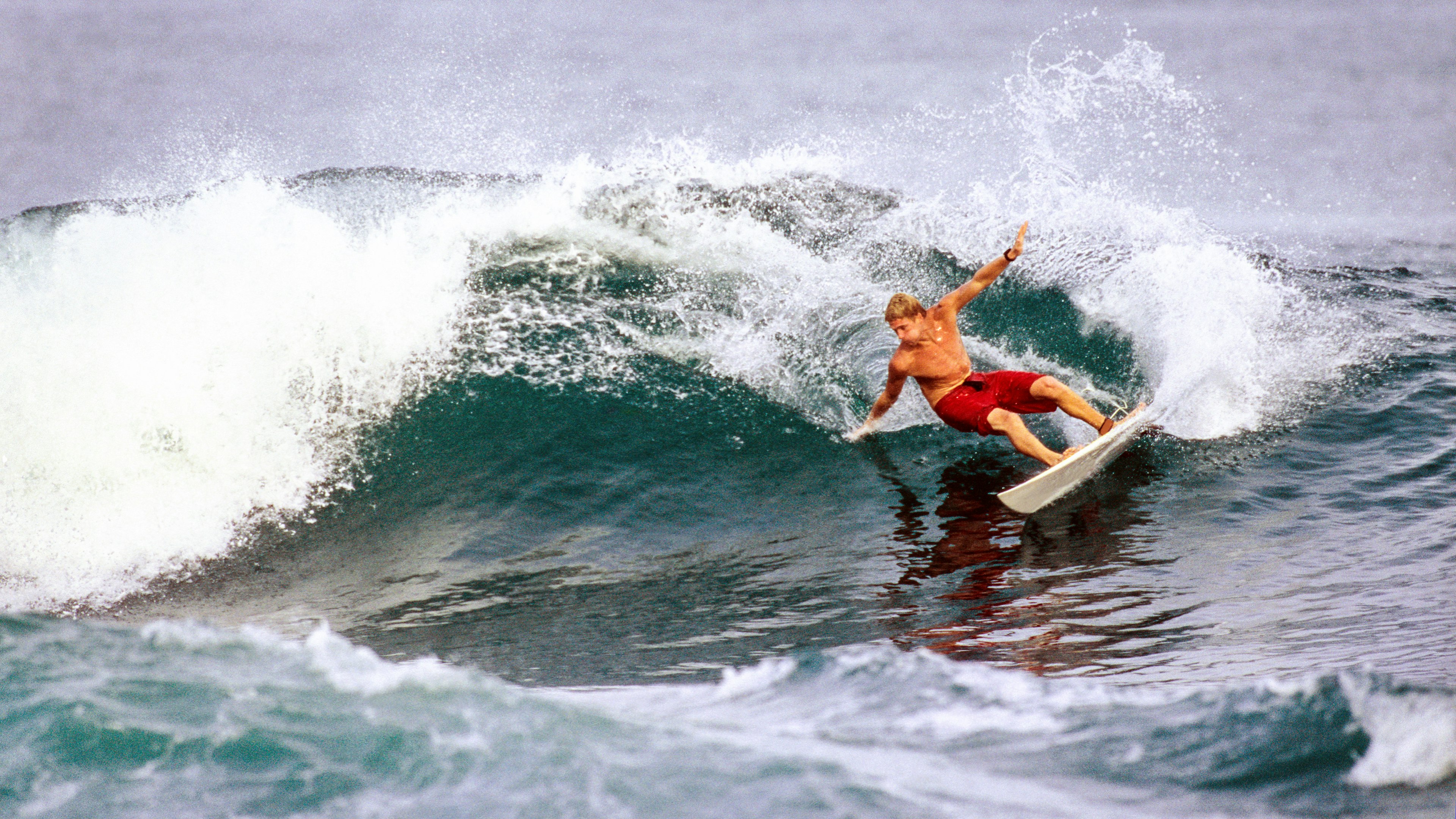 A man surfing in the Caribbean Sea off Bocas del Toro, Panama