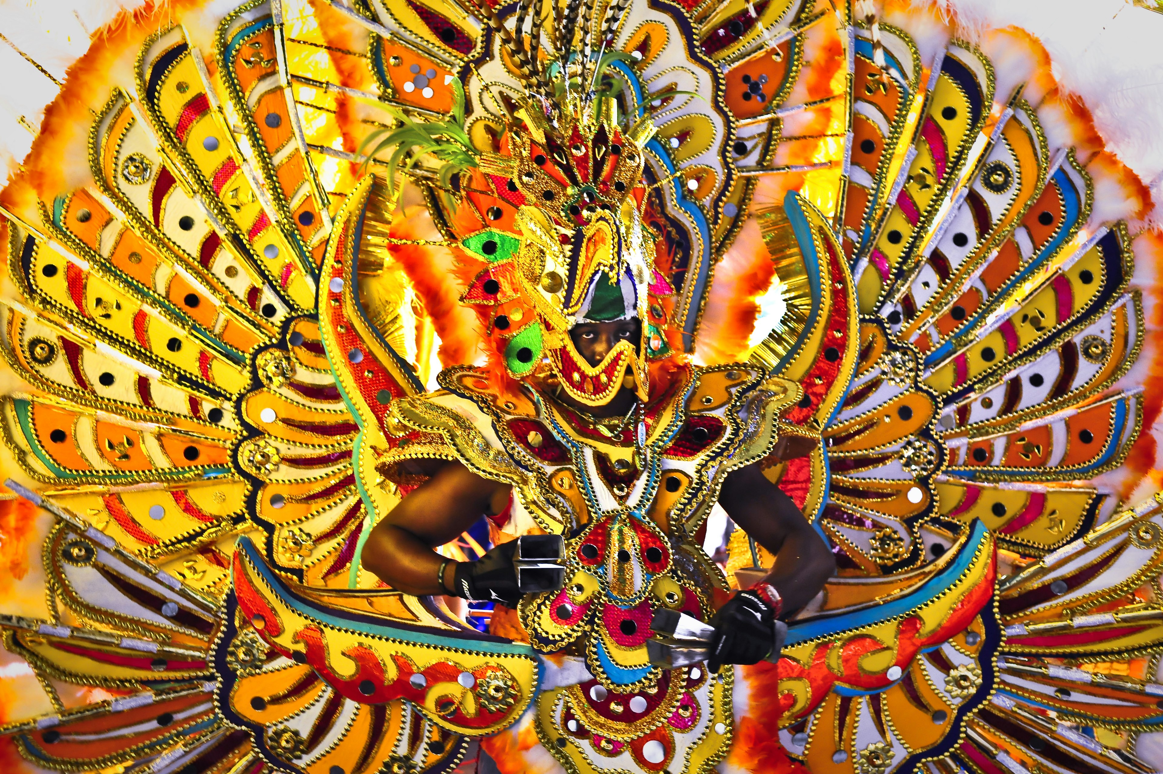 A man poses in a splendid colorful costume dancing during Junkanoo in Bahamas.