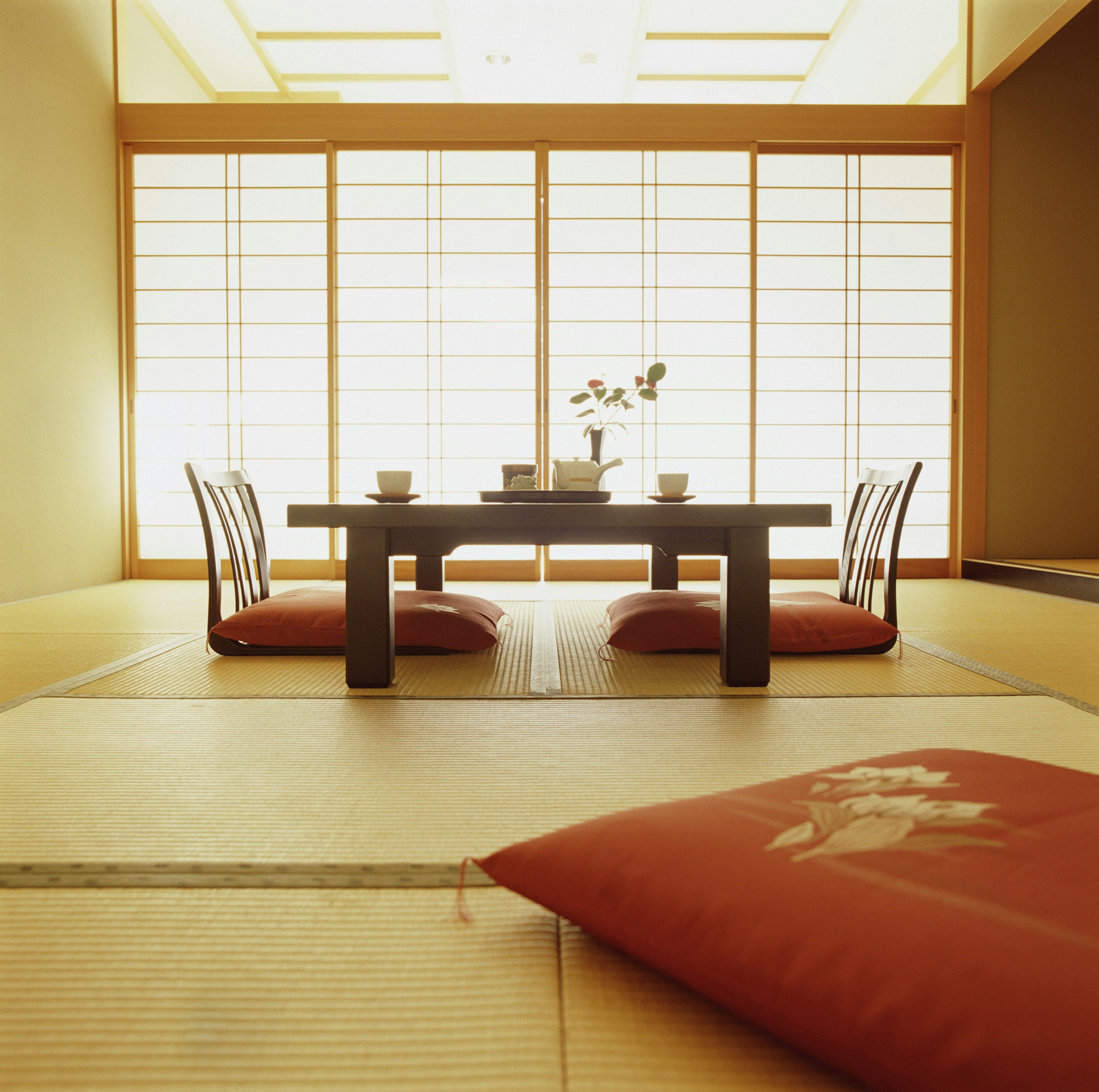 A traditional Japanese low table with floor cushions and back support in an inn