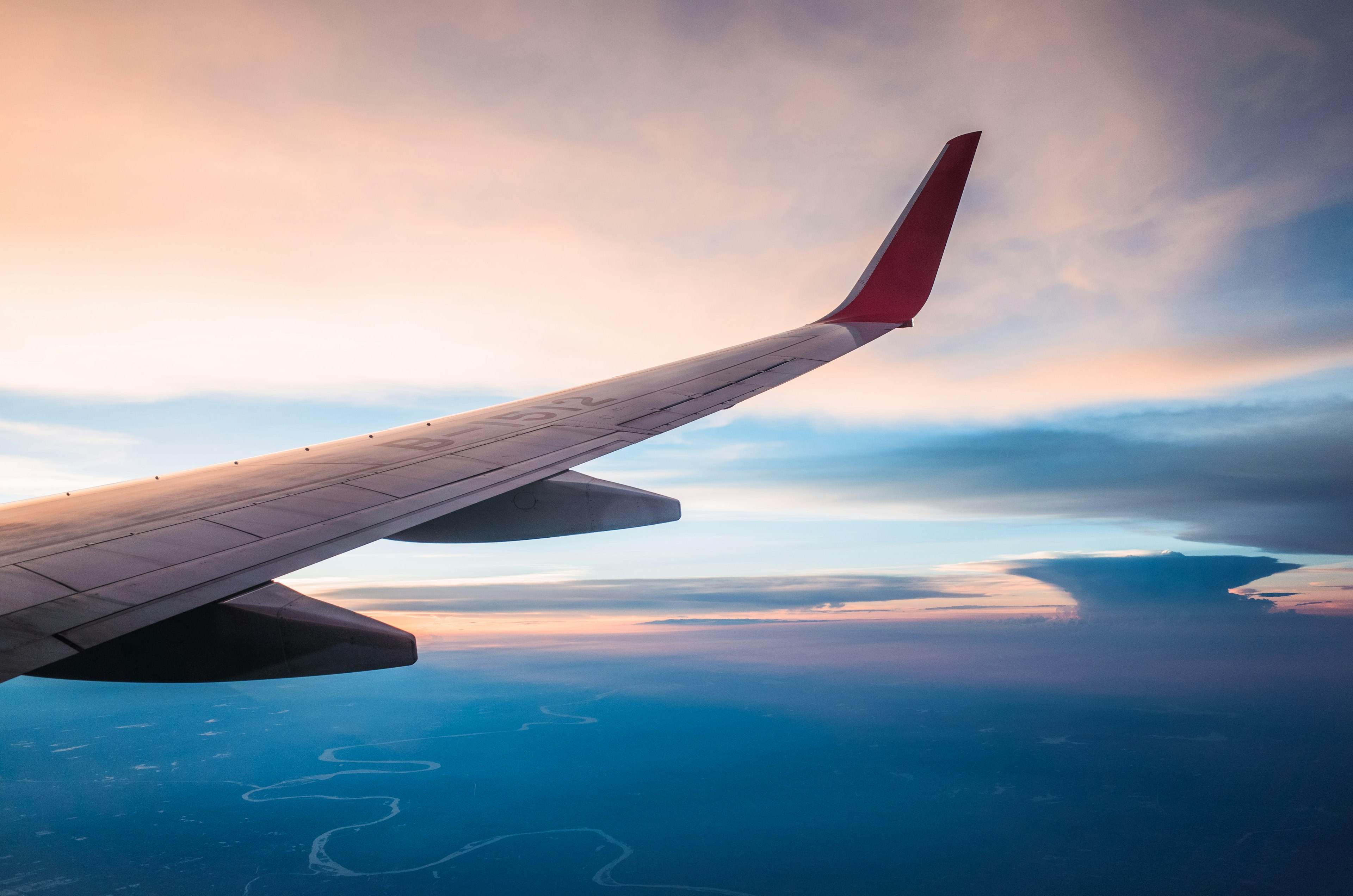 A shot out the window of a plane over the wing of a plane in flight