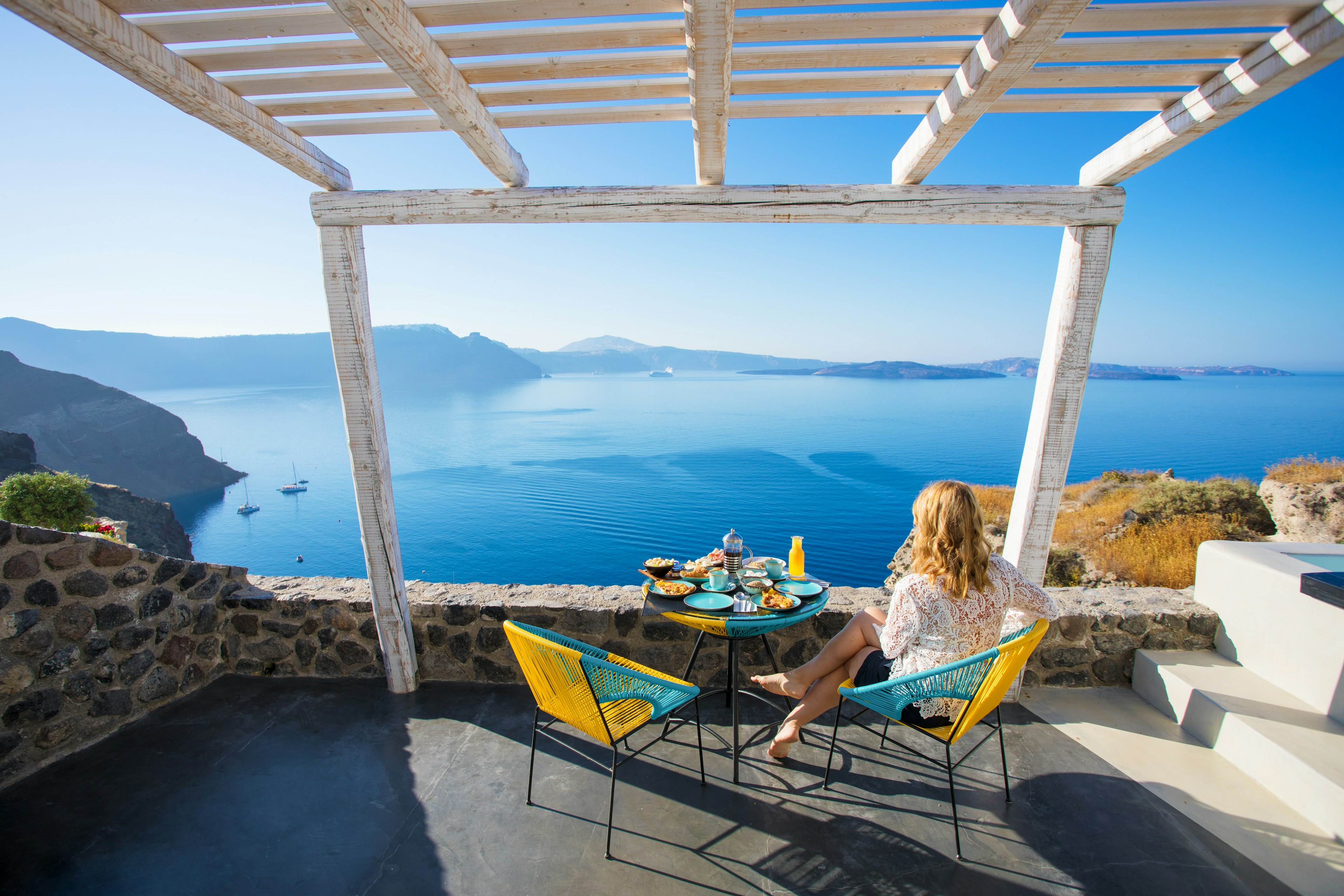 Woman enjoying breakfast with a beautiful view over Santorini