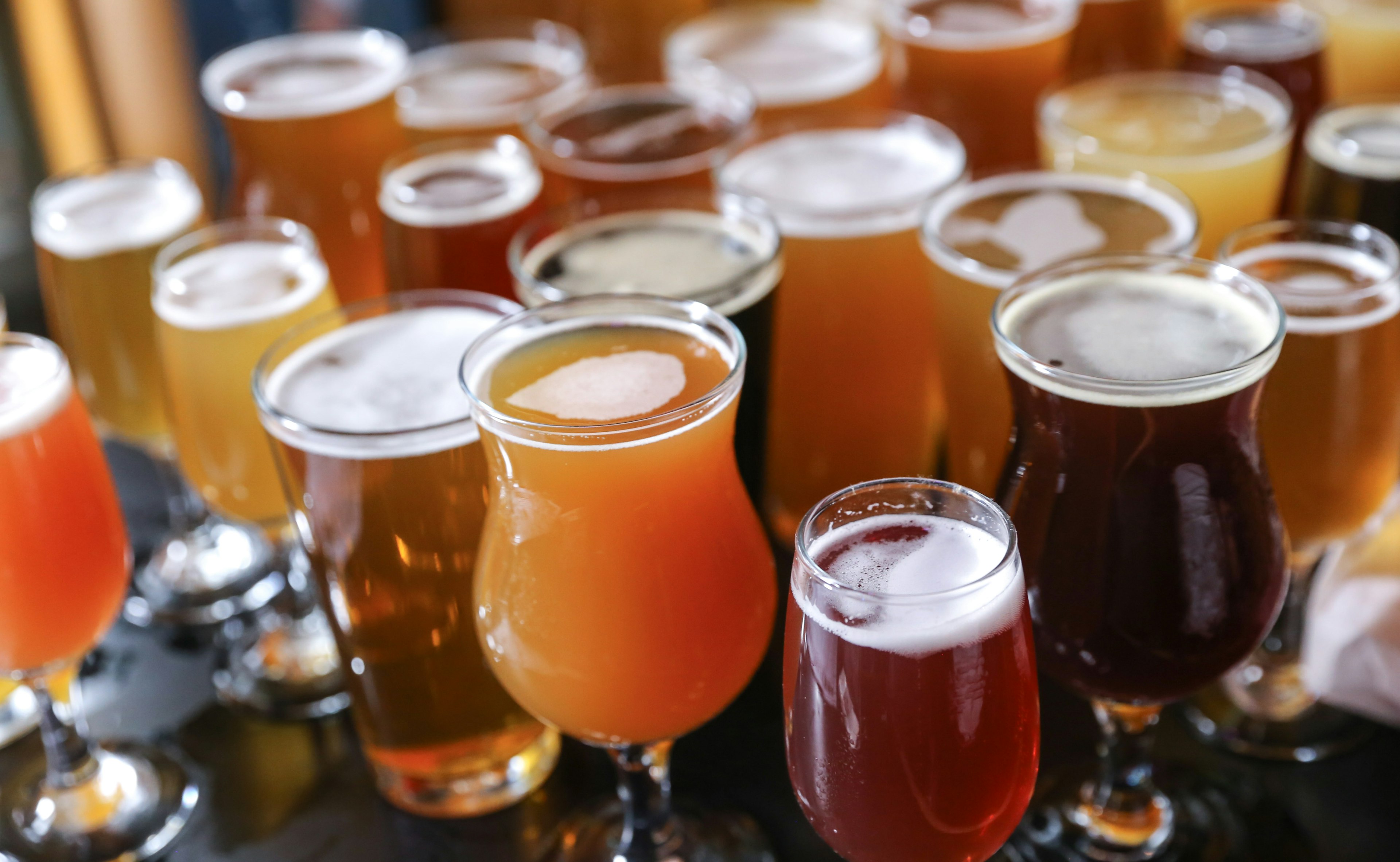 A cluster of glasses holding different varieties of craft beer