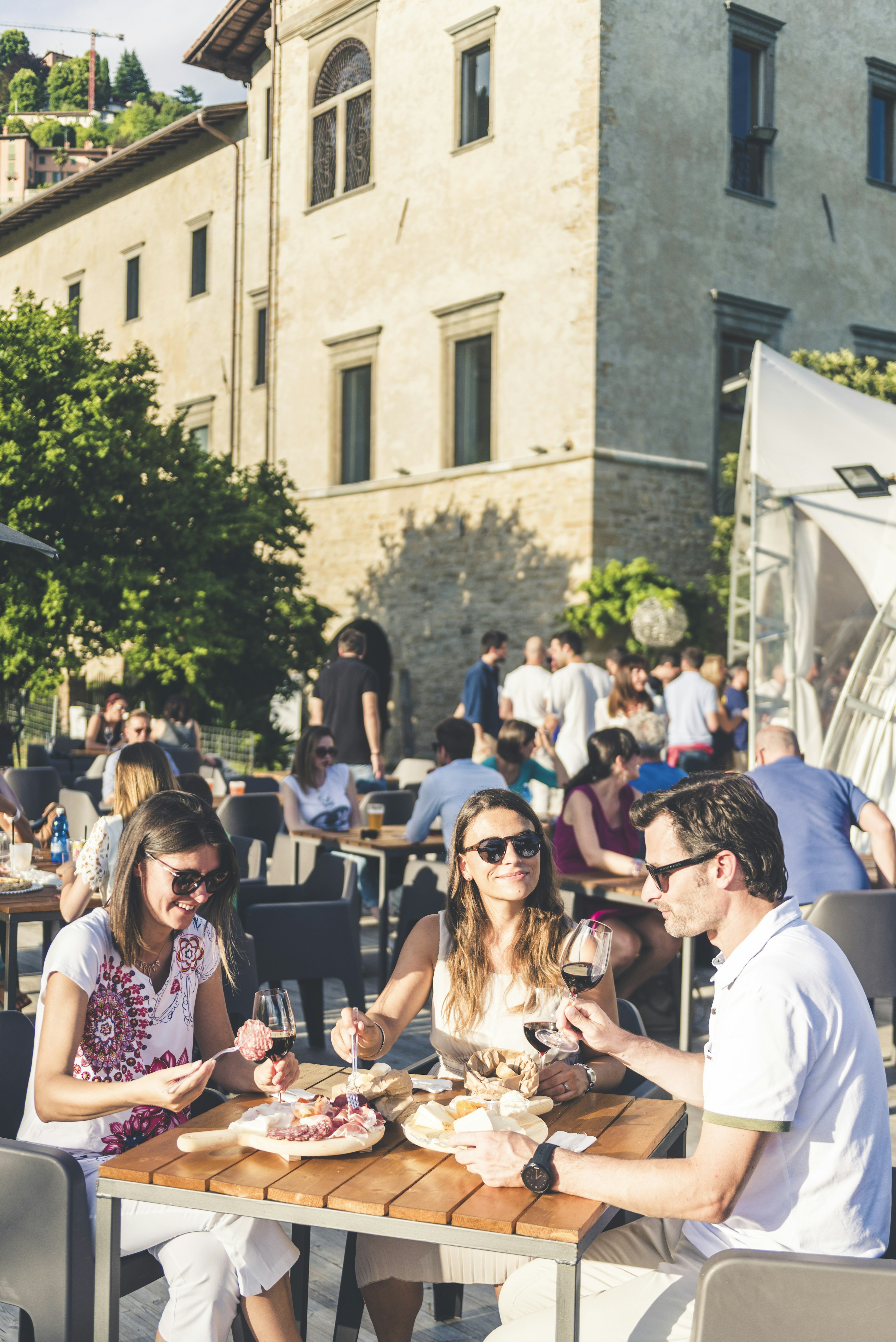 Friends eating out in an outdoor restaurant, Italy.