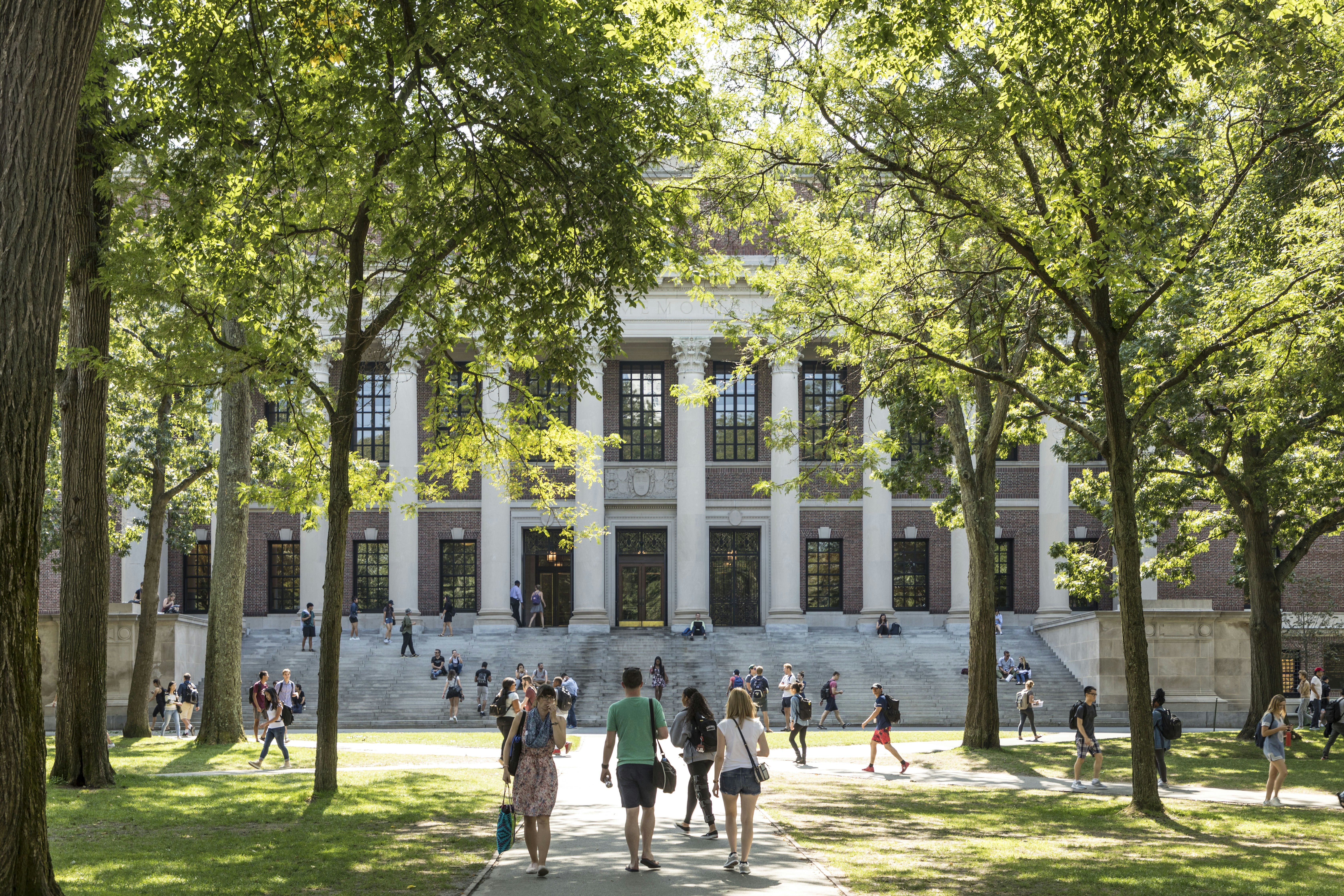 Students and tourists rest in lawn chairs in Harvard Yard