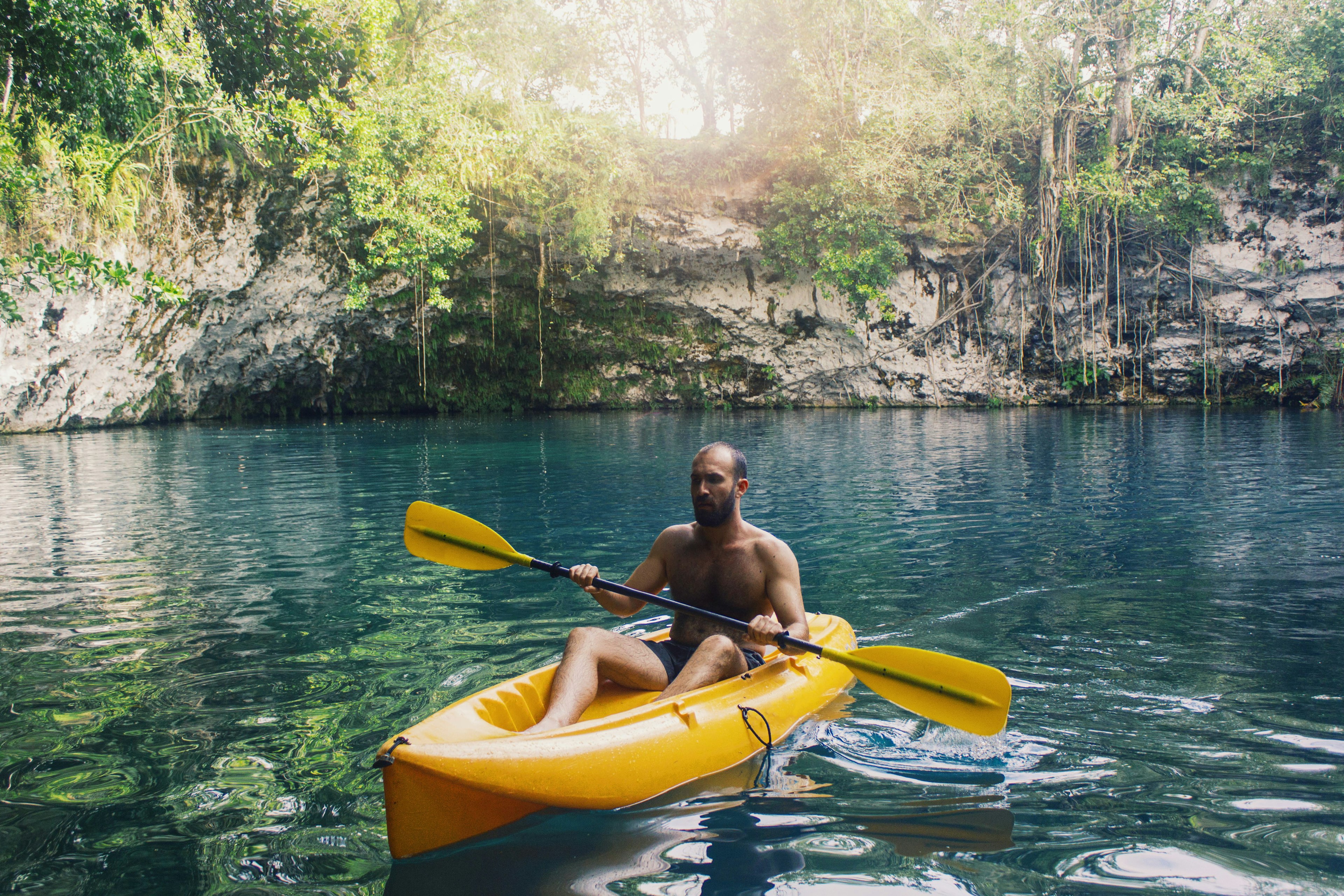 Young man kayaking on yellow boat