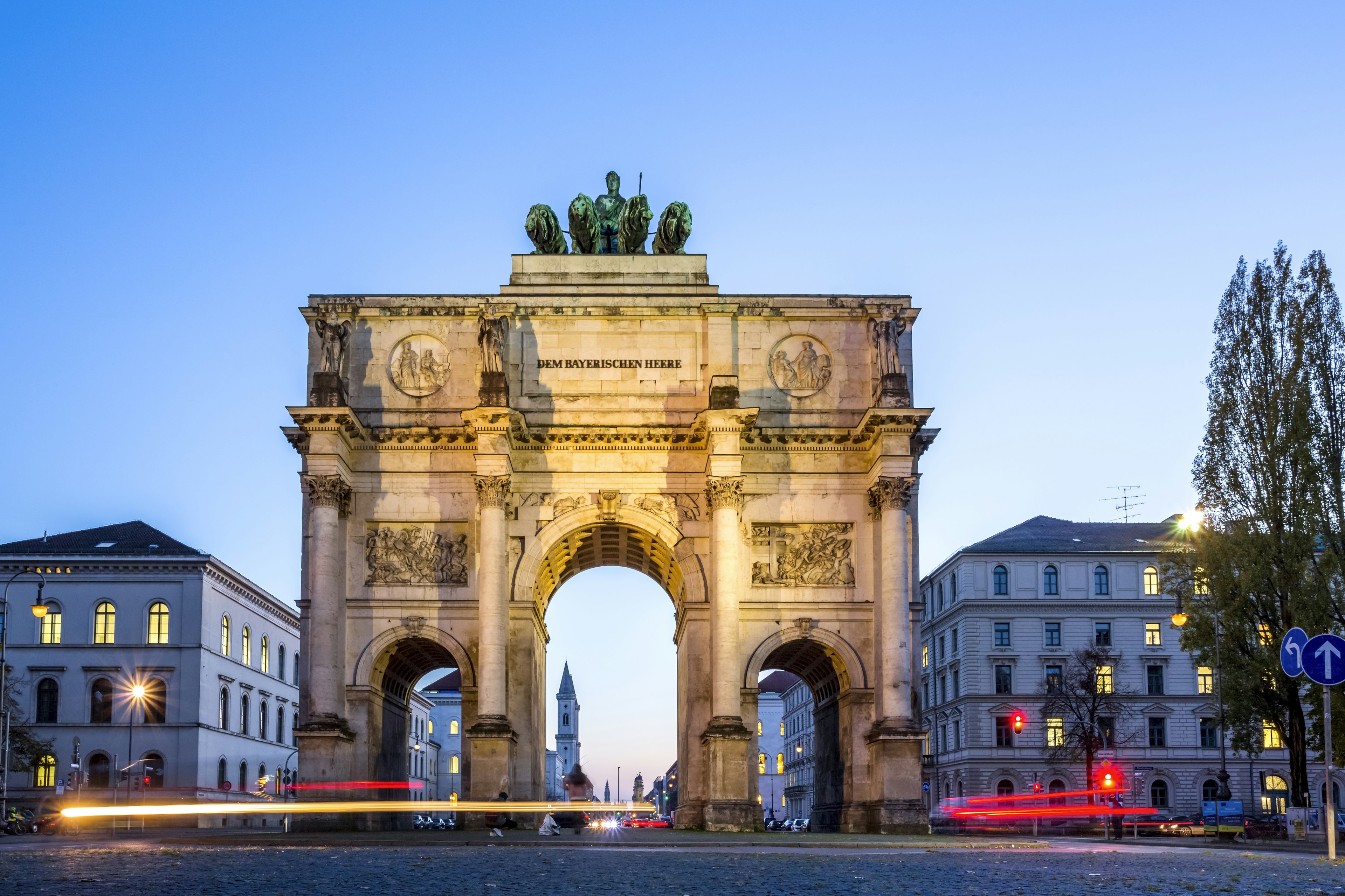 A large archway over a road in a city at dusk