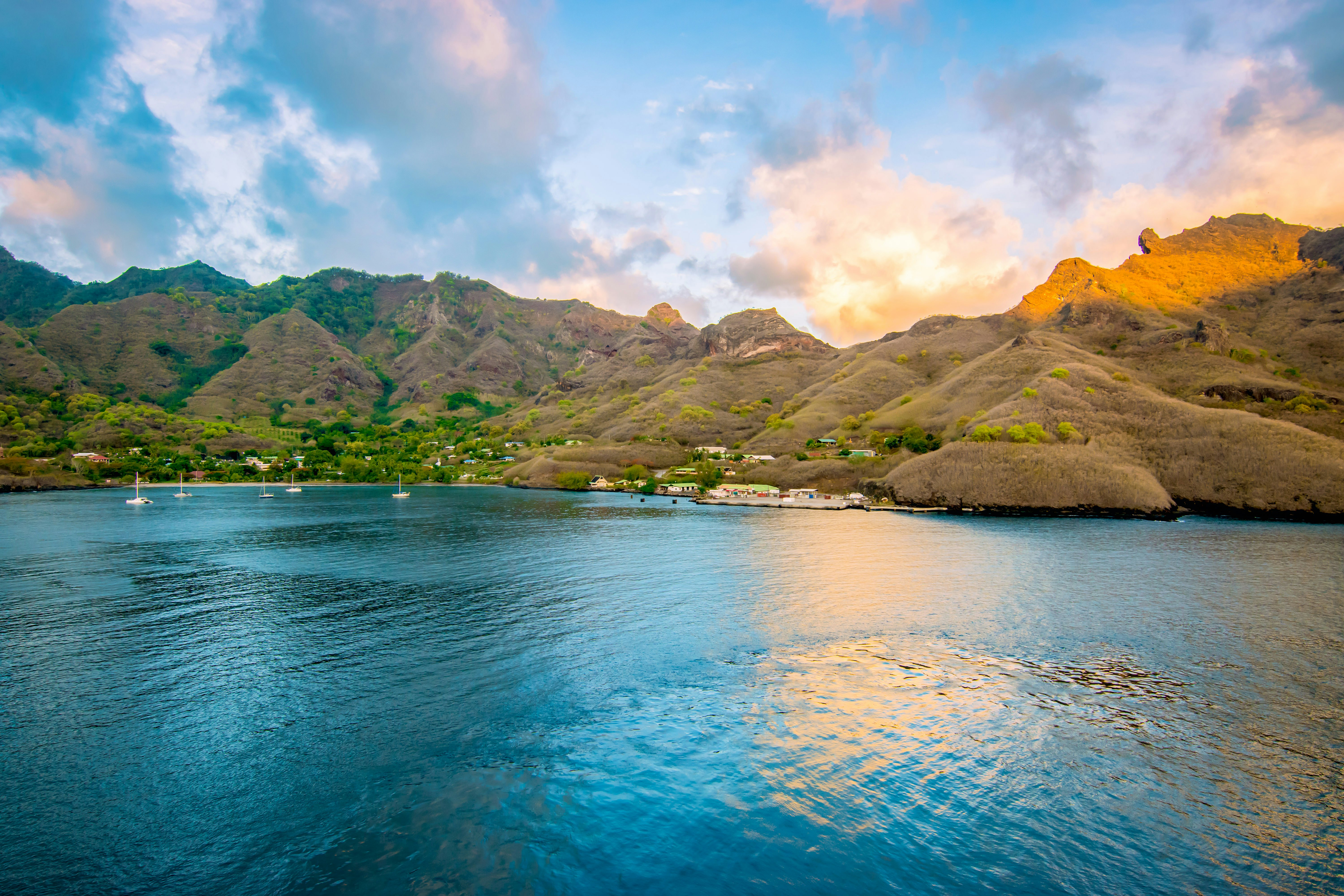 A hilly island with a small settlement by the edge of the water.