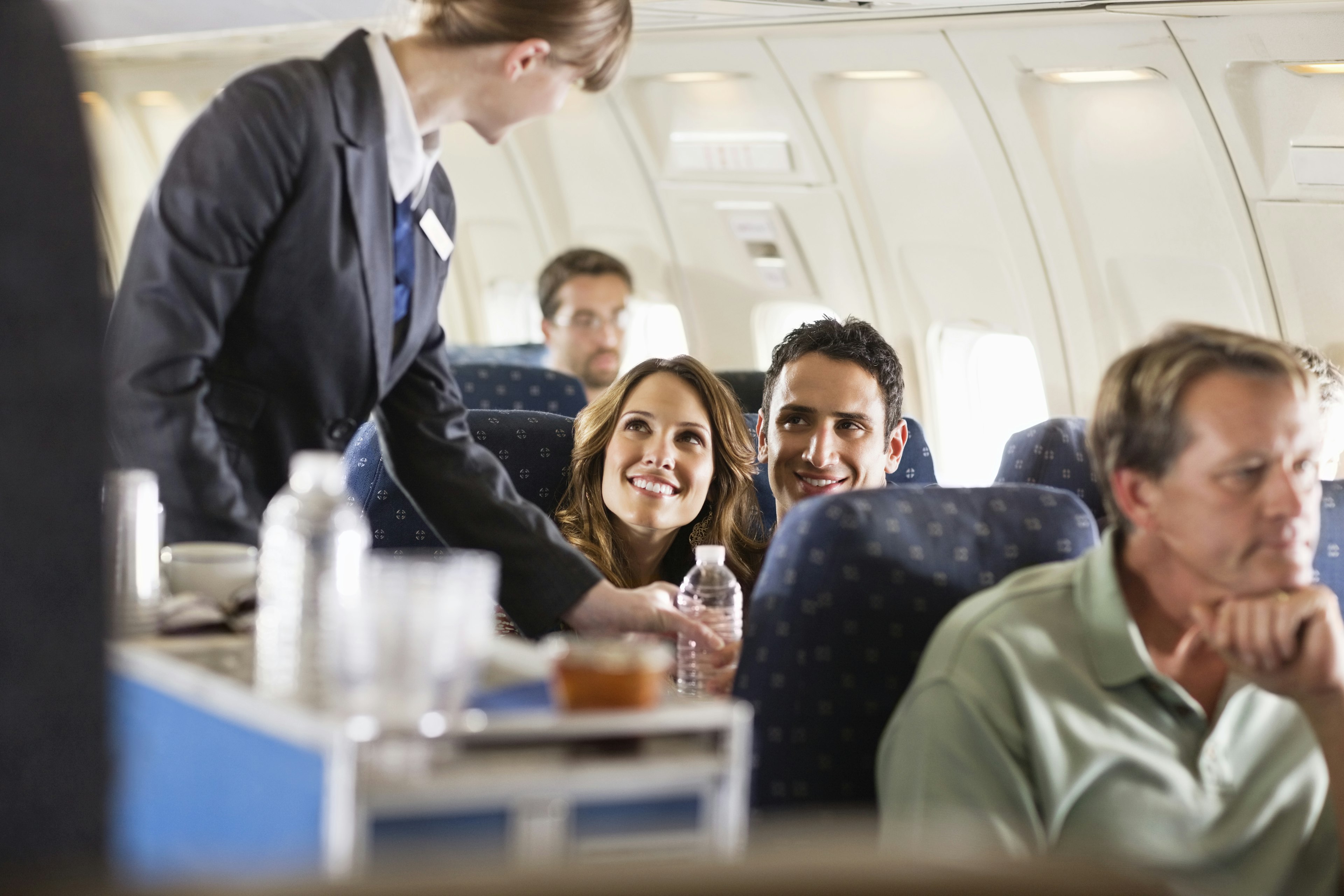 Flight attendant serving customers on an airplane