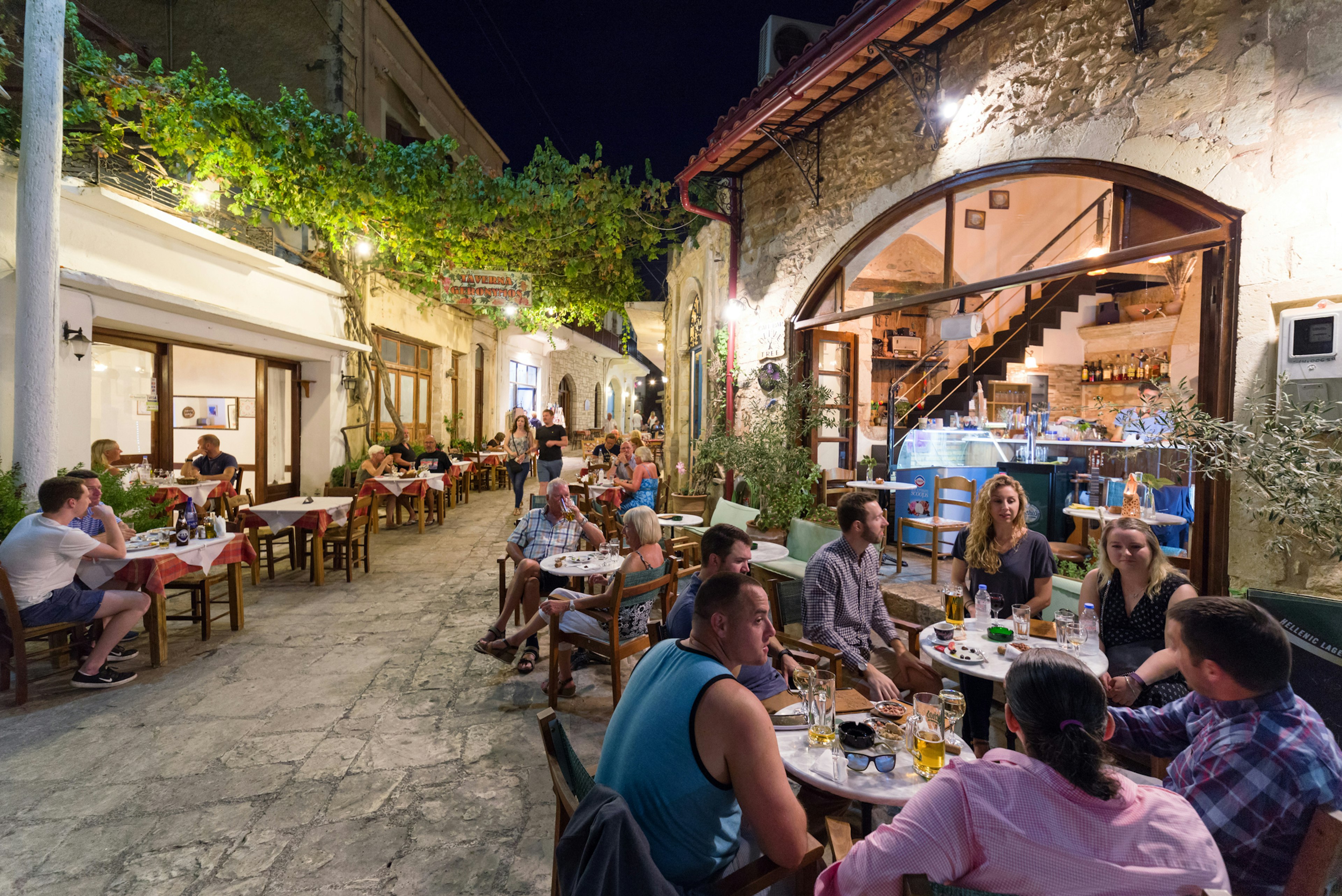 People eat outside tavernas in a village in Crete