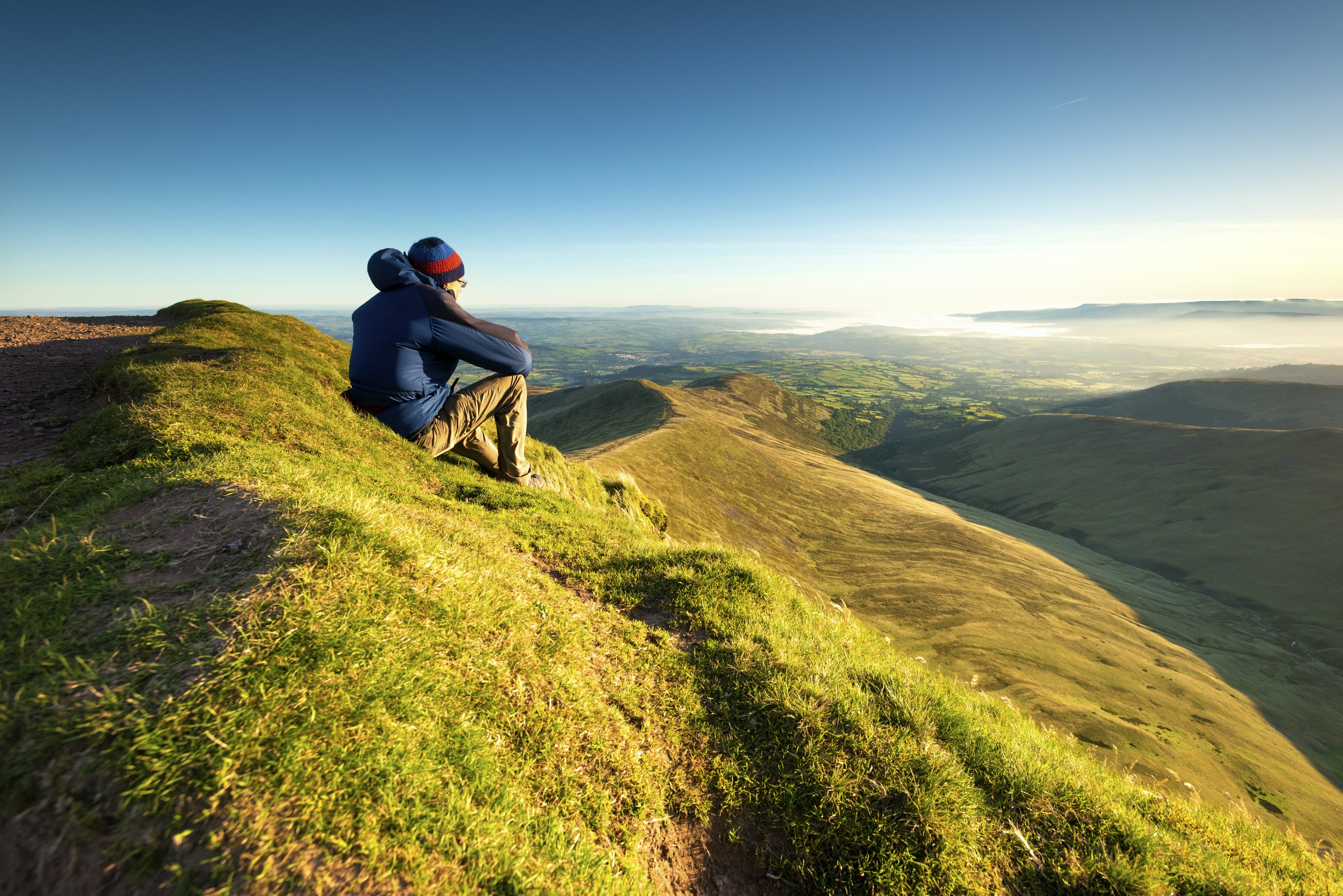 Hiker looking over the Brecon Beacons from Pen y Fan