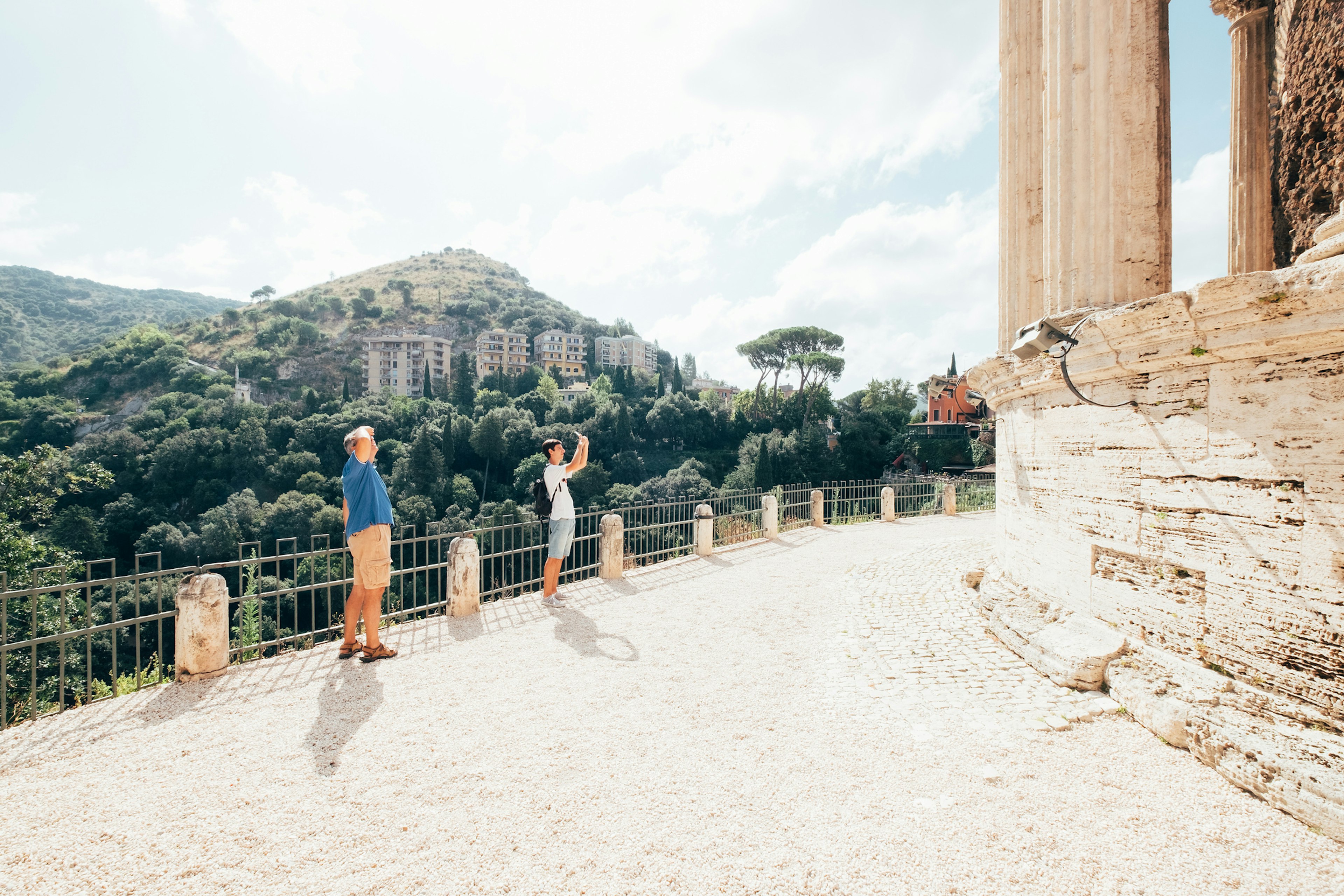 Father and son looking upwards at some Roman Ruins