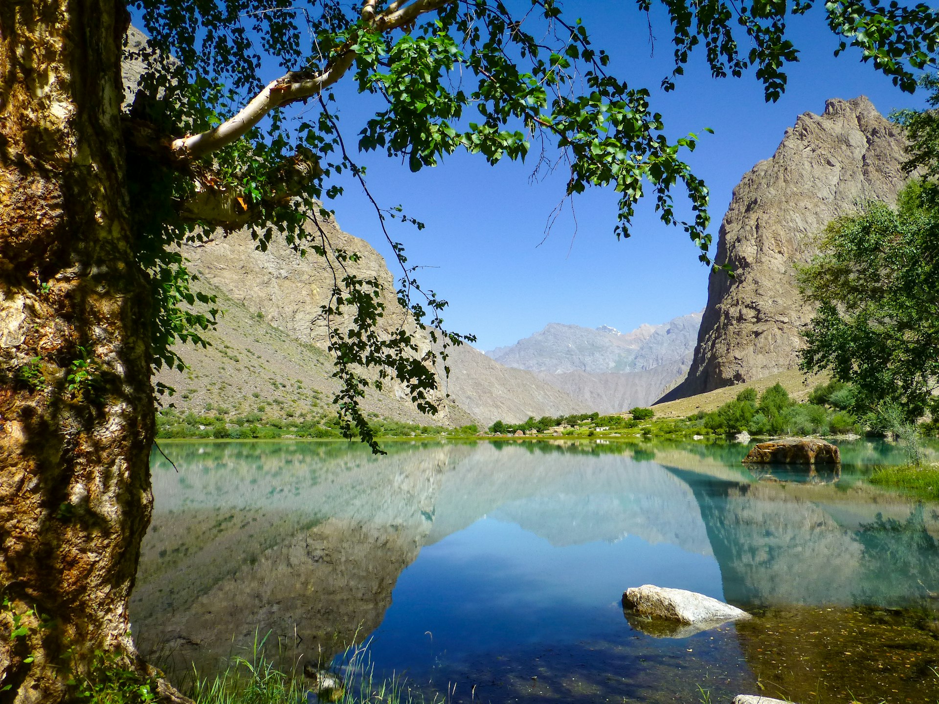 Teal water surrounded by jagged rocky mountains, Jizeu Valley, Kazakhstan