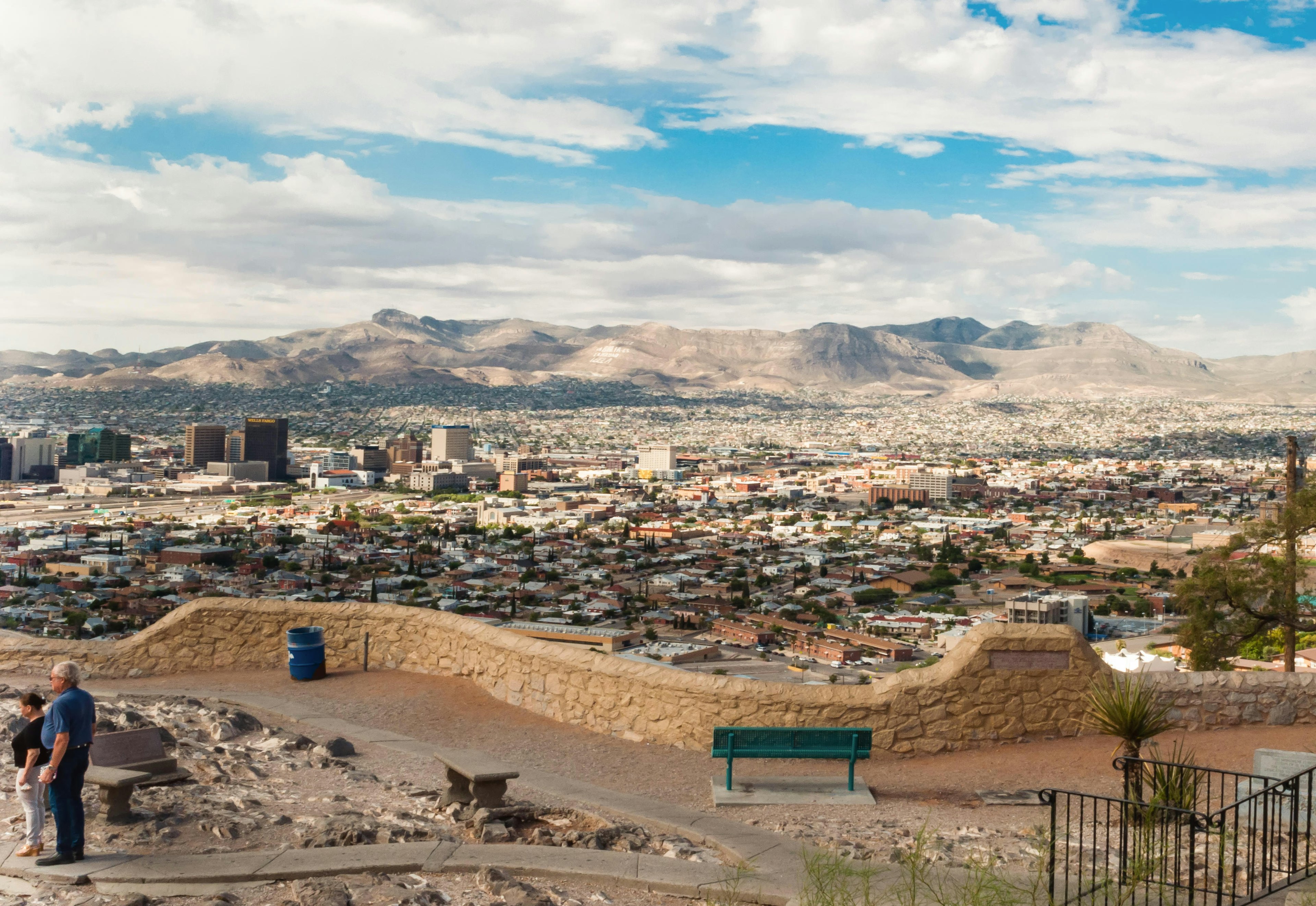 A couple takes in view of the city and mountains beyond from Murchison Park in El Paso, TX, USA