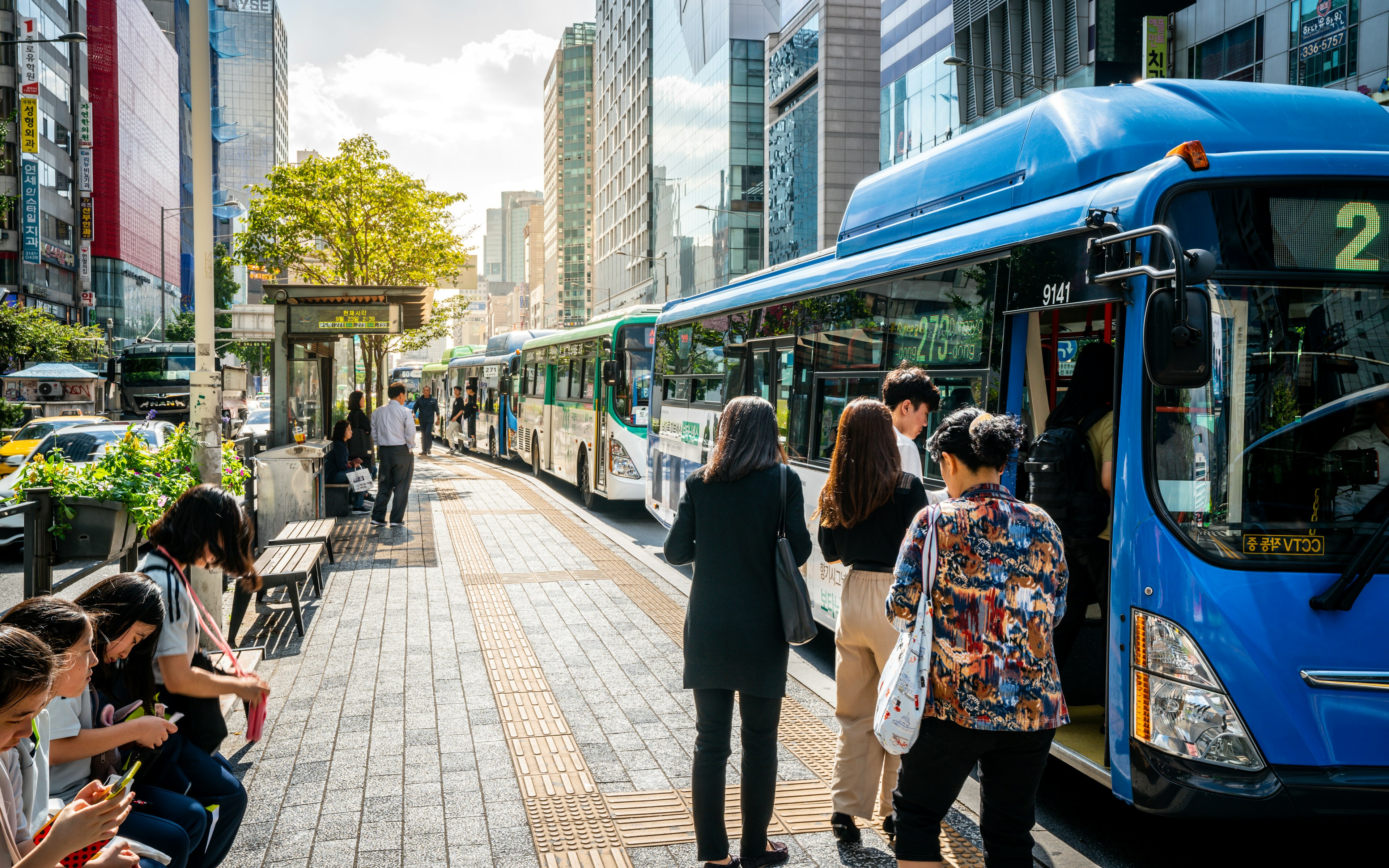 Passengers waiting for buses in Seoul