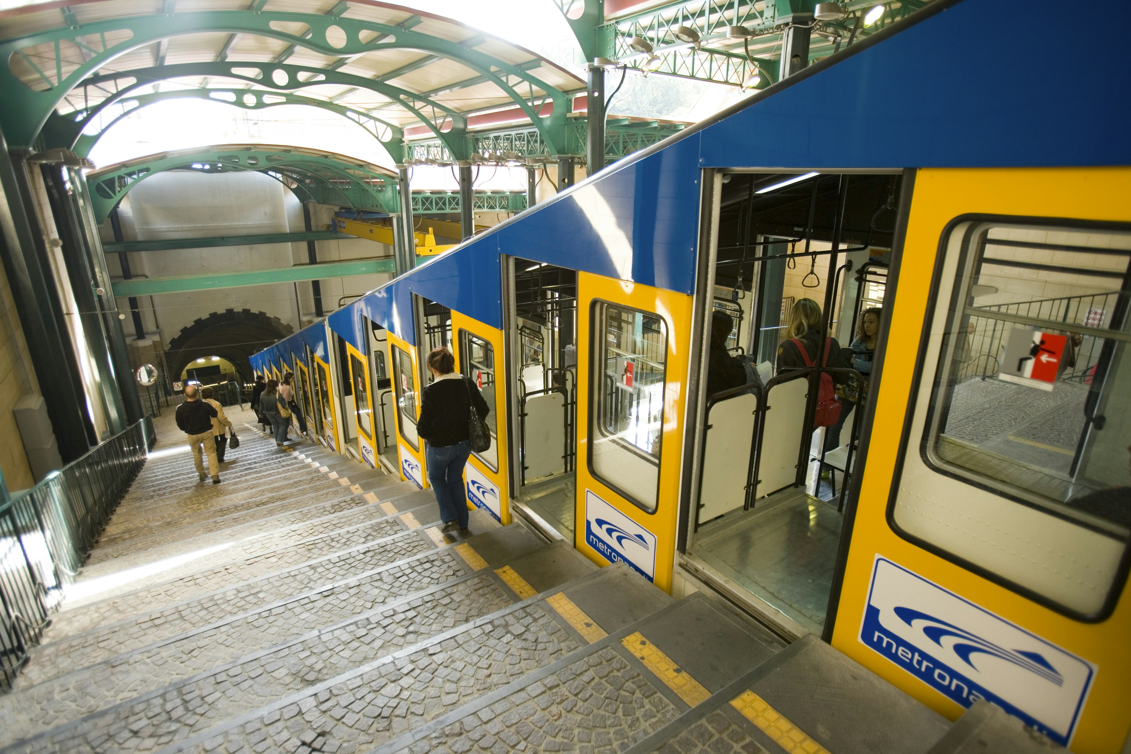 People walking down the stairs next to a funicular railway in Vomero