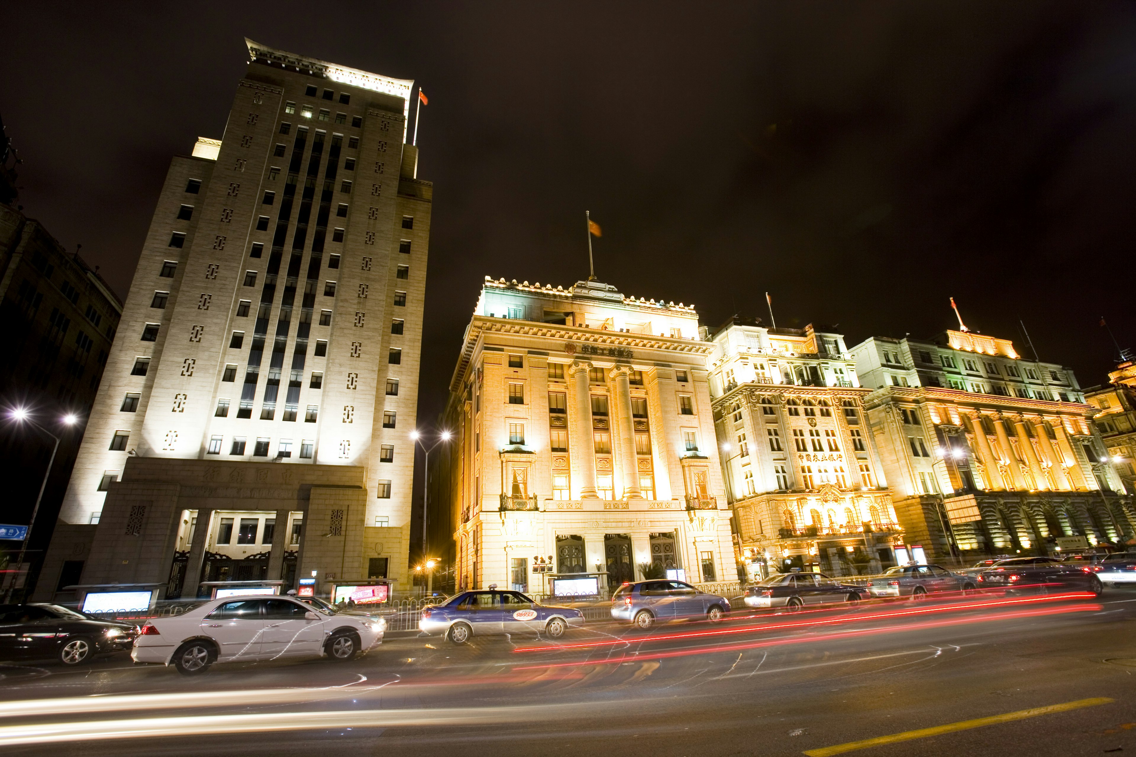 The Bund's colonial buildings at night with traffic in front