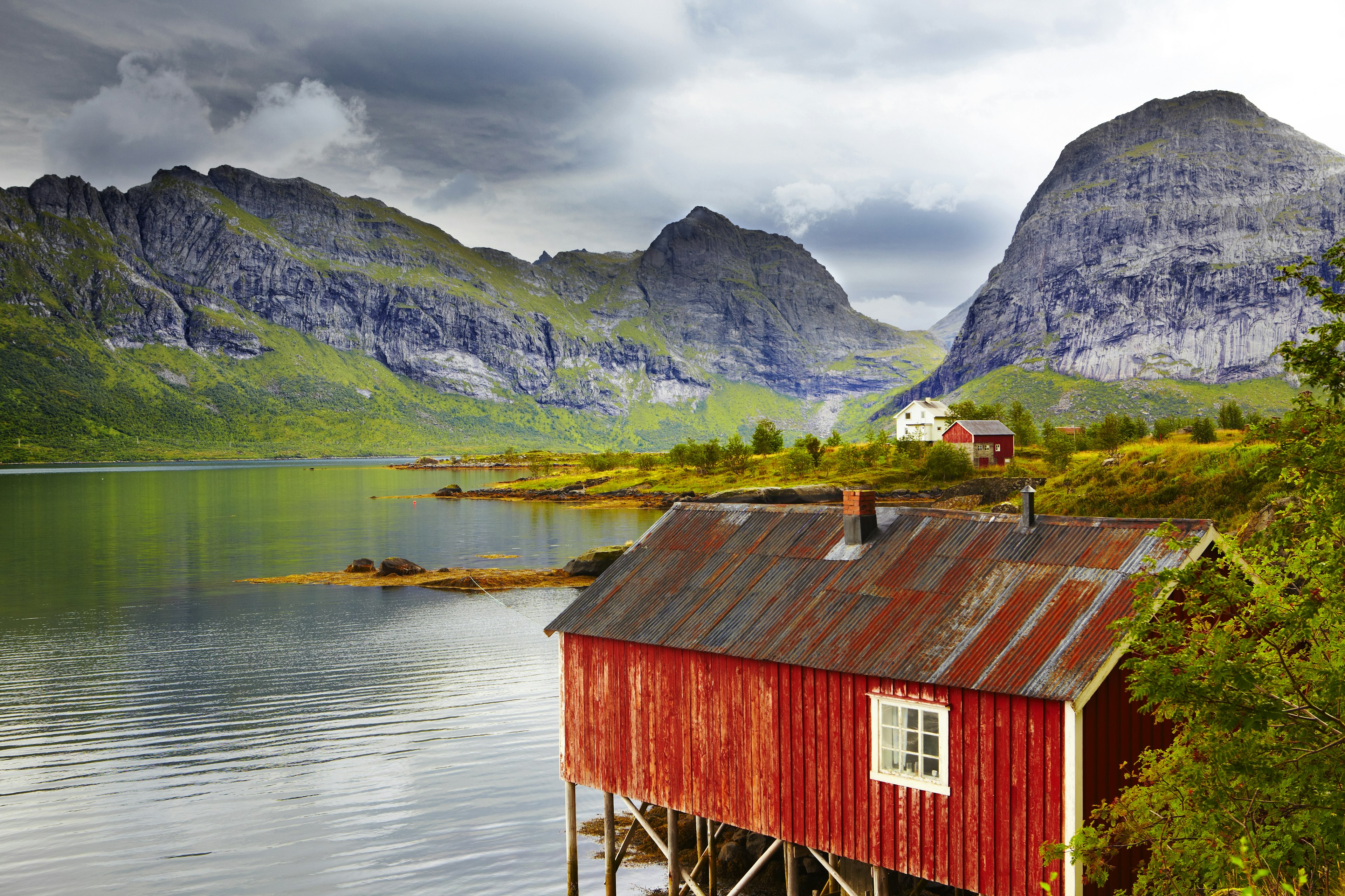 Stilted red fisher's huts against a backdrop of steep mountains