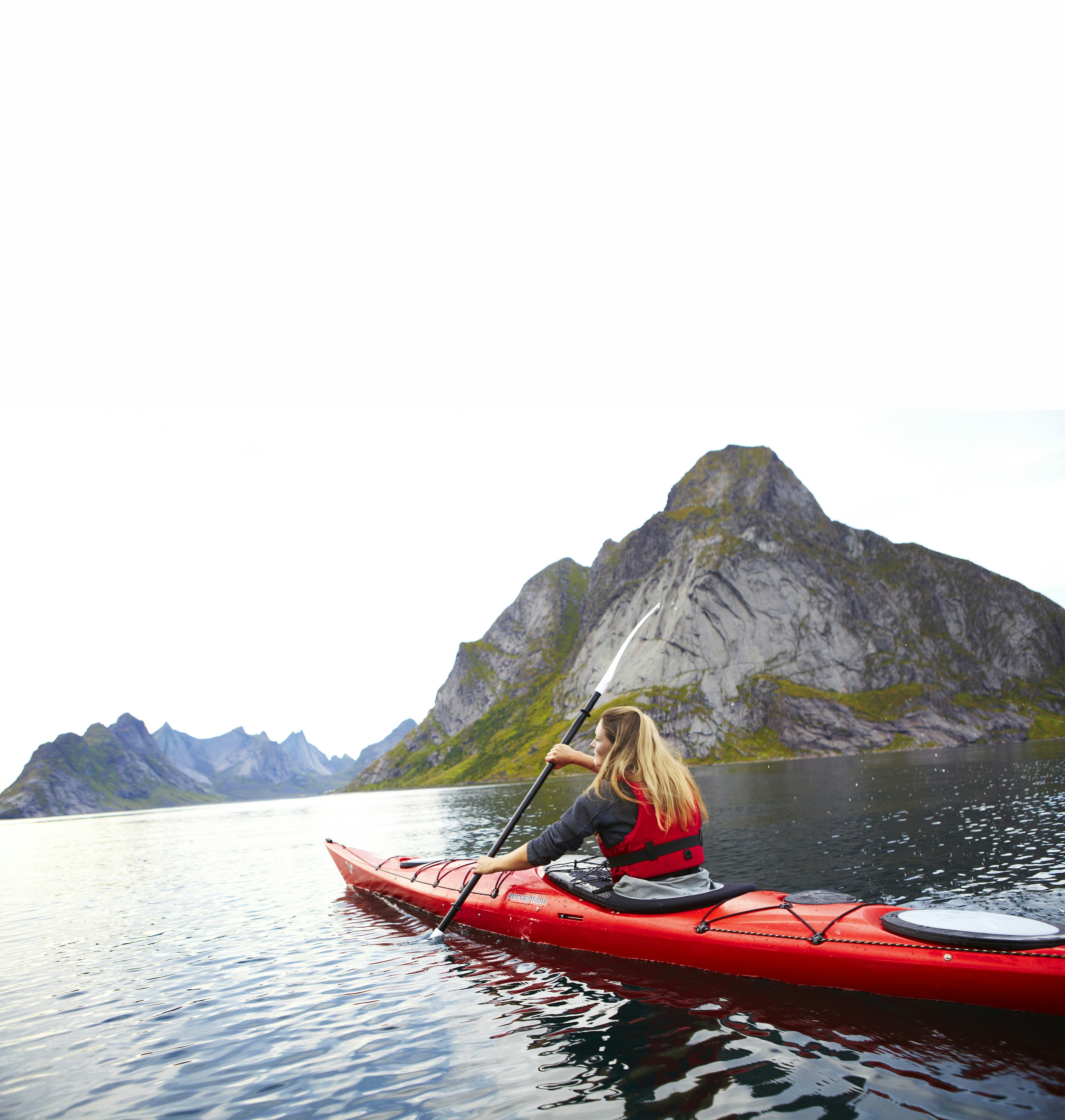 A woman kayaking through a fjord