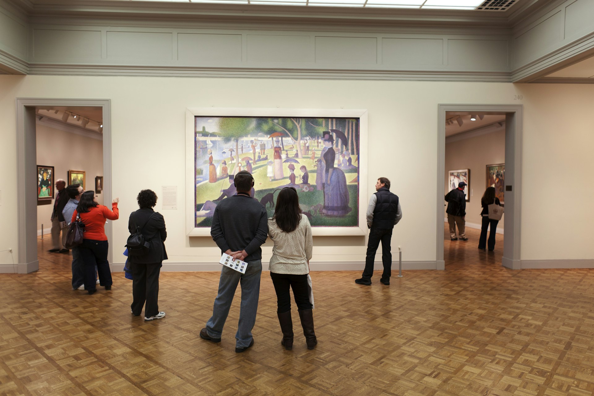 People viewing 'A Sunday on La Grande Jatte' by Georges-Pierre Seurat at Art Institute of Chicago.