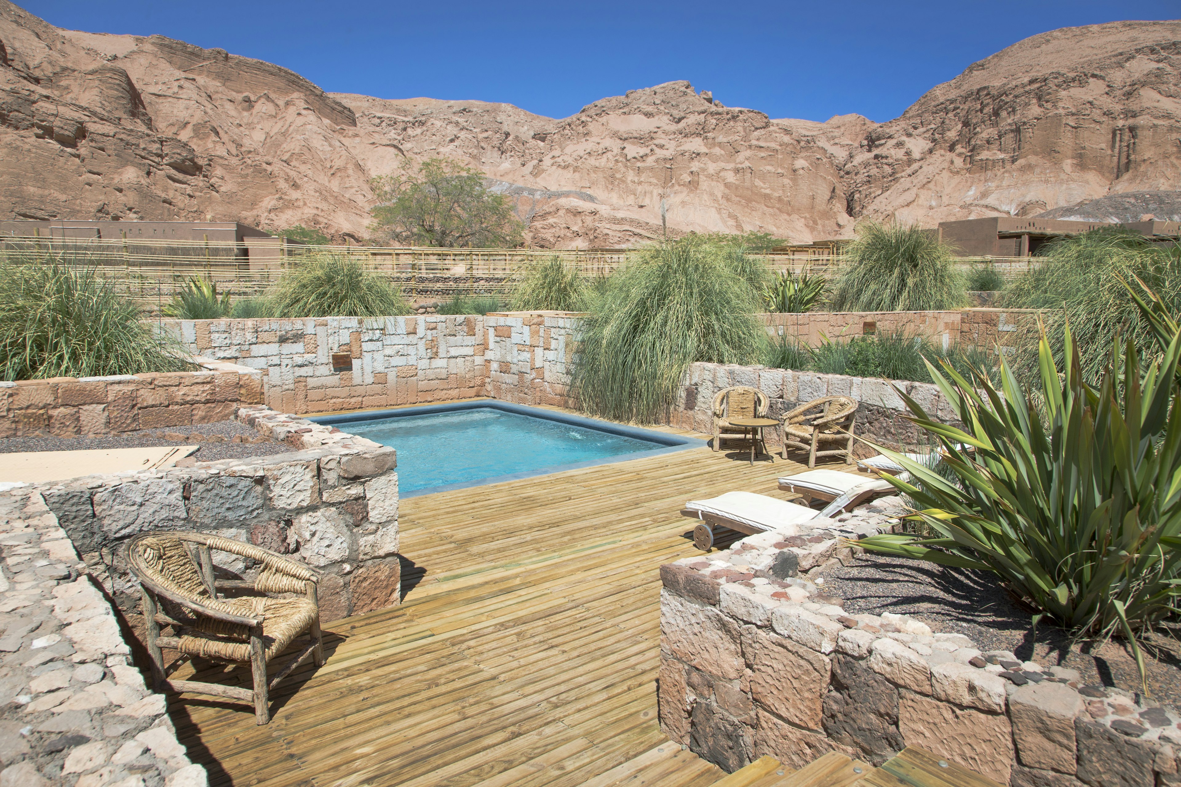 Pool area at Alto Atacama Desert Lodge & Spa with rocky outcrops beyond