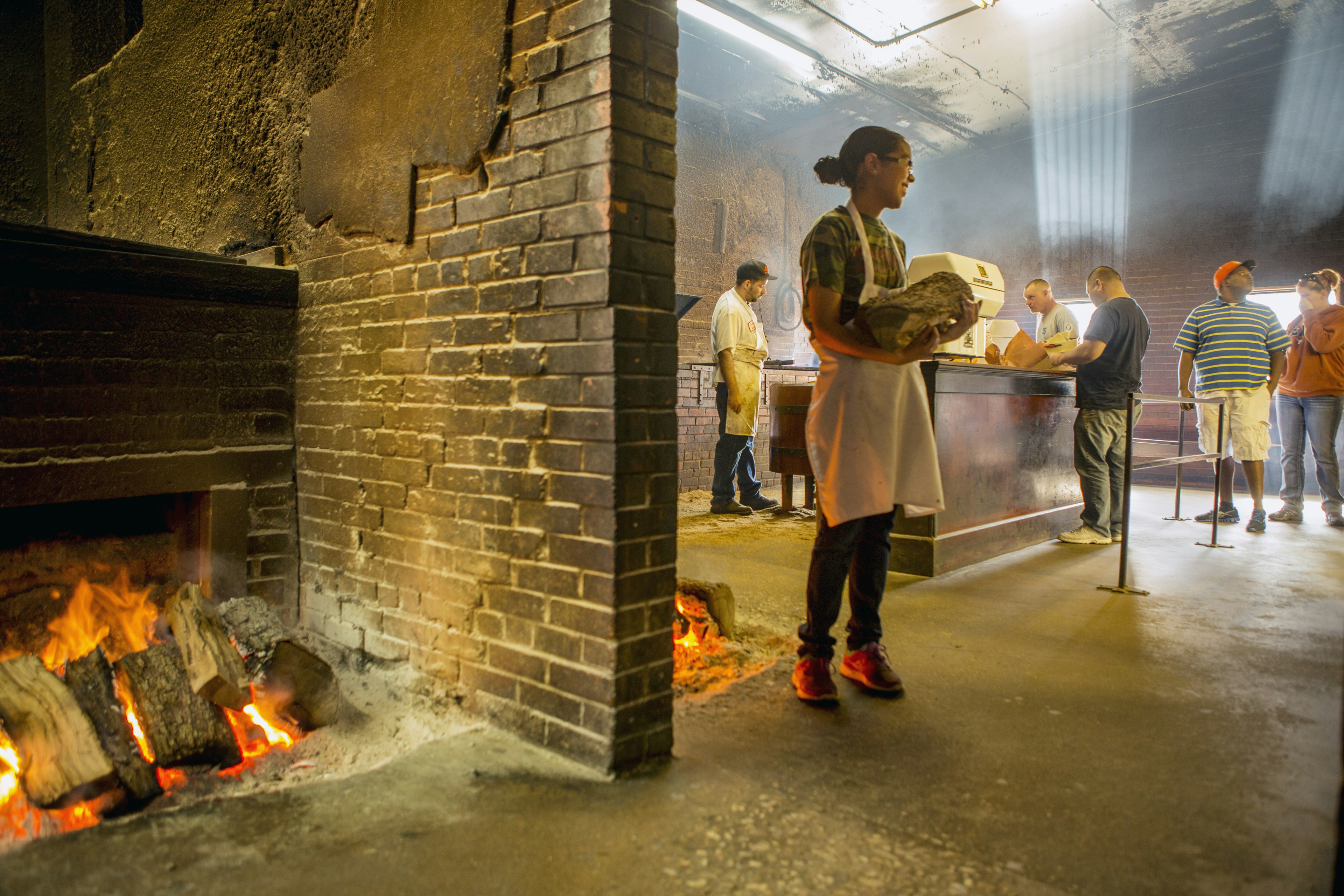 A worker with firewood for the never-ending barbecue fire at Smitty's Market in Lockhart, Texas