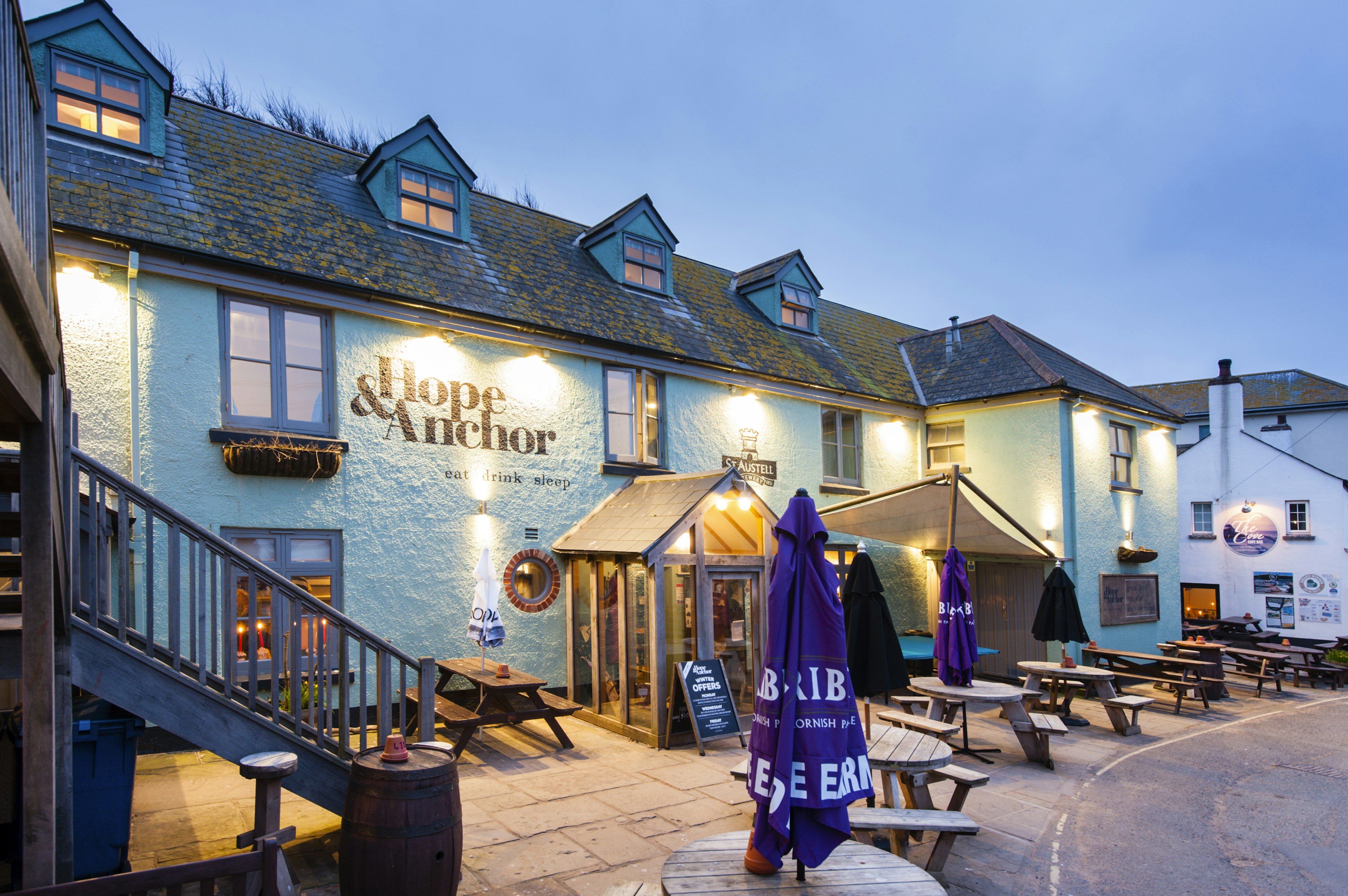 A British pub with tables outdoors in the evening light.