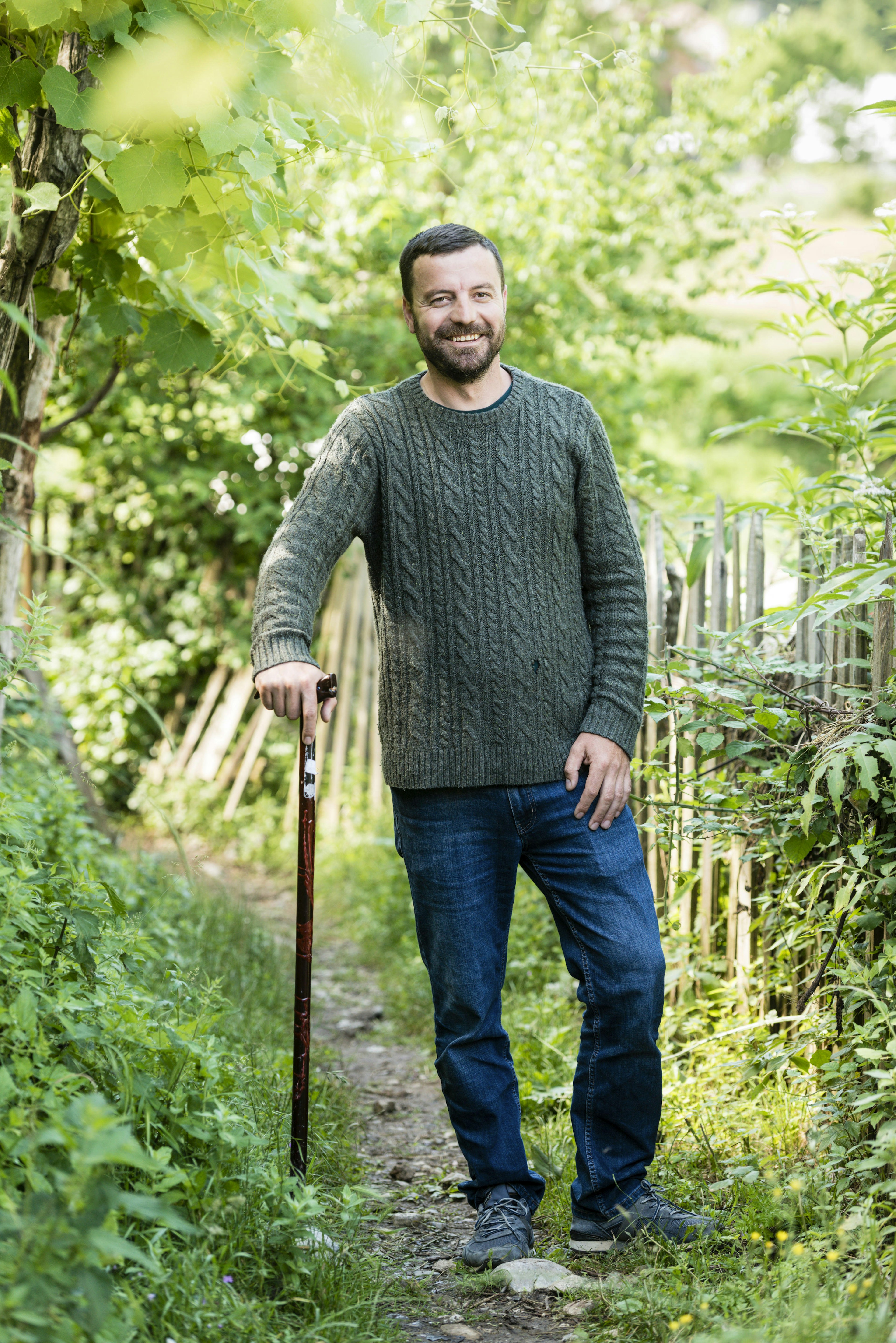 Male guide with walking stick on path