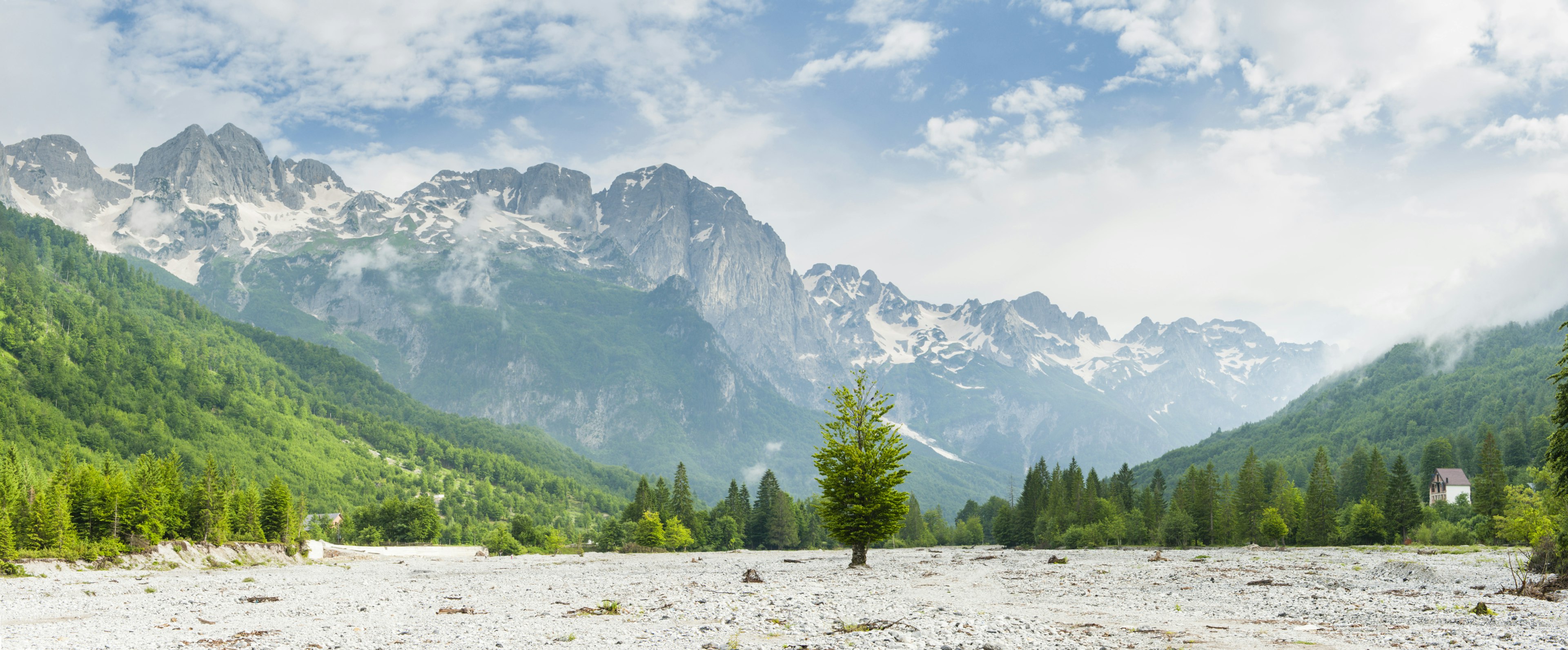 A panorama of a mountain landscape from a dry riverbed