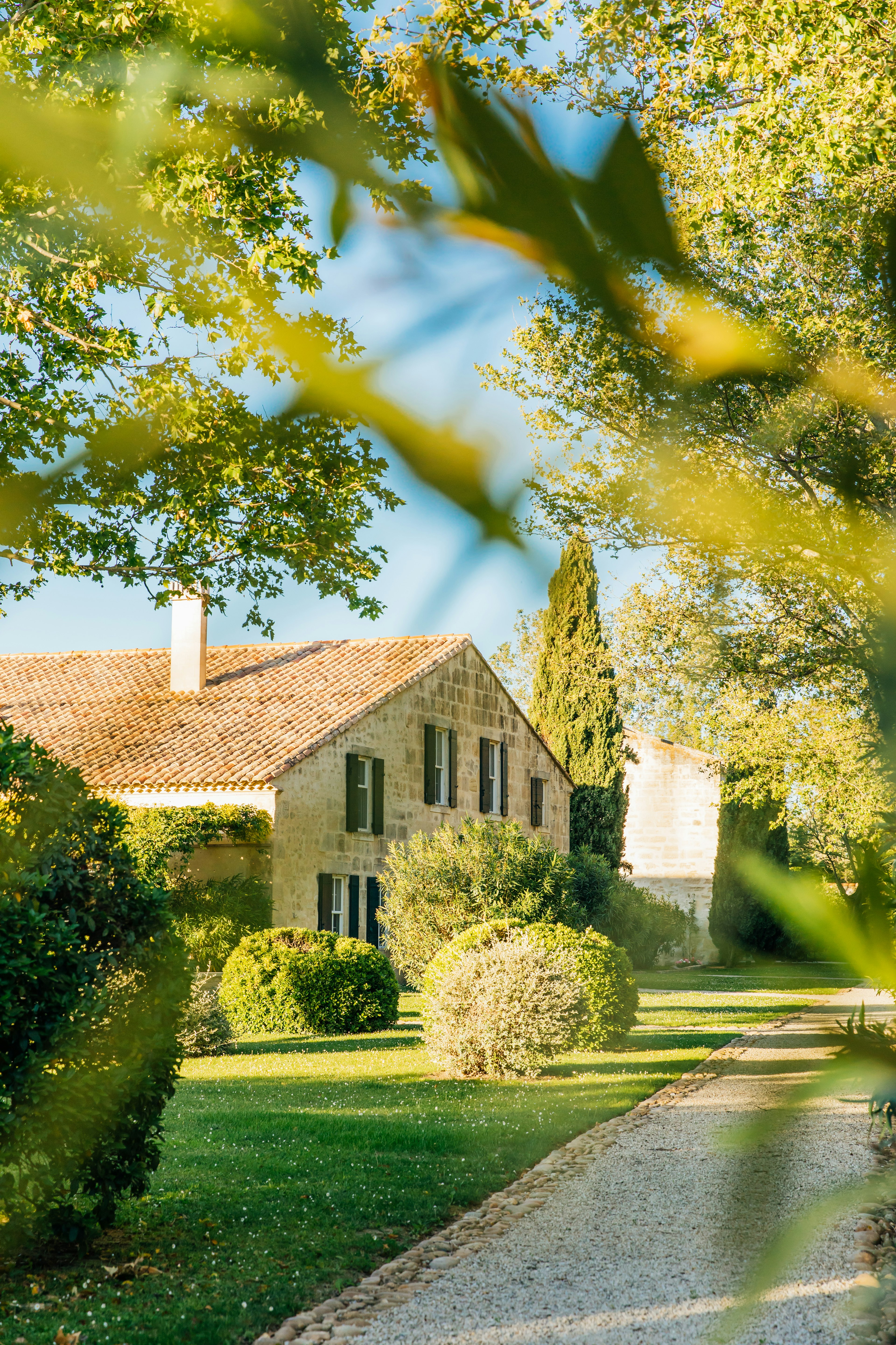 A stone farmhouse in the countryside, surrounded by trees