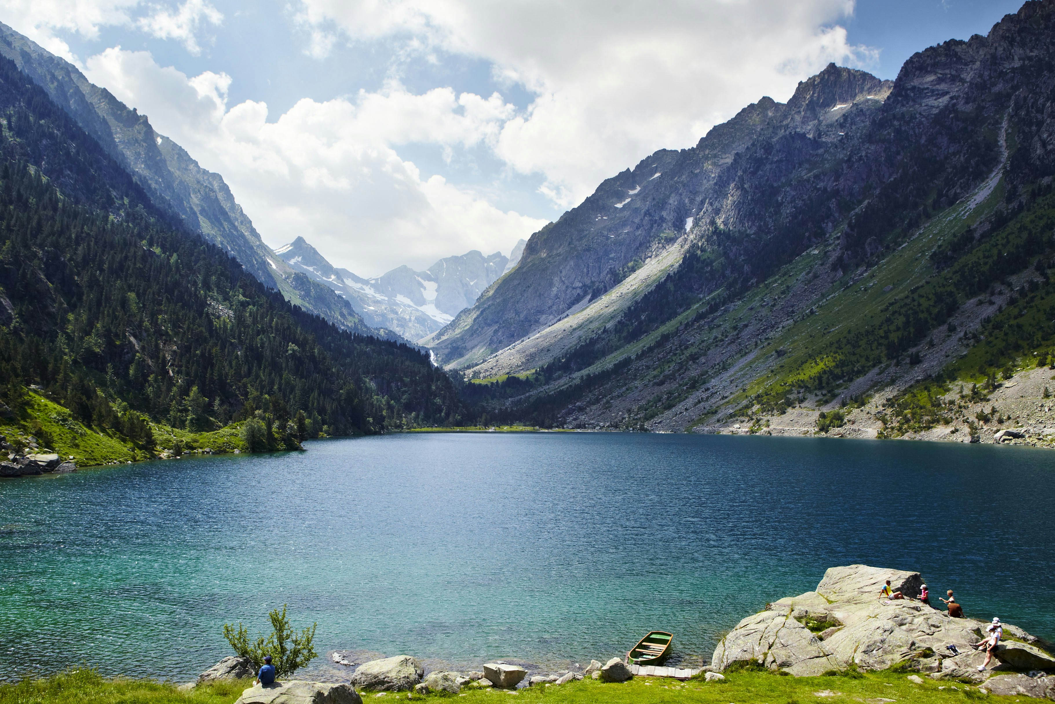 People sit on a rock at the glacial amphitheatre lake of the Cirque de gavarnie