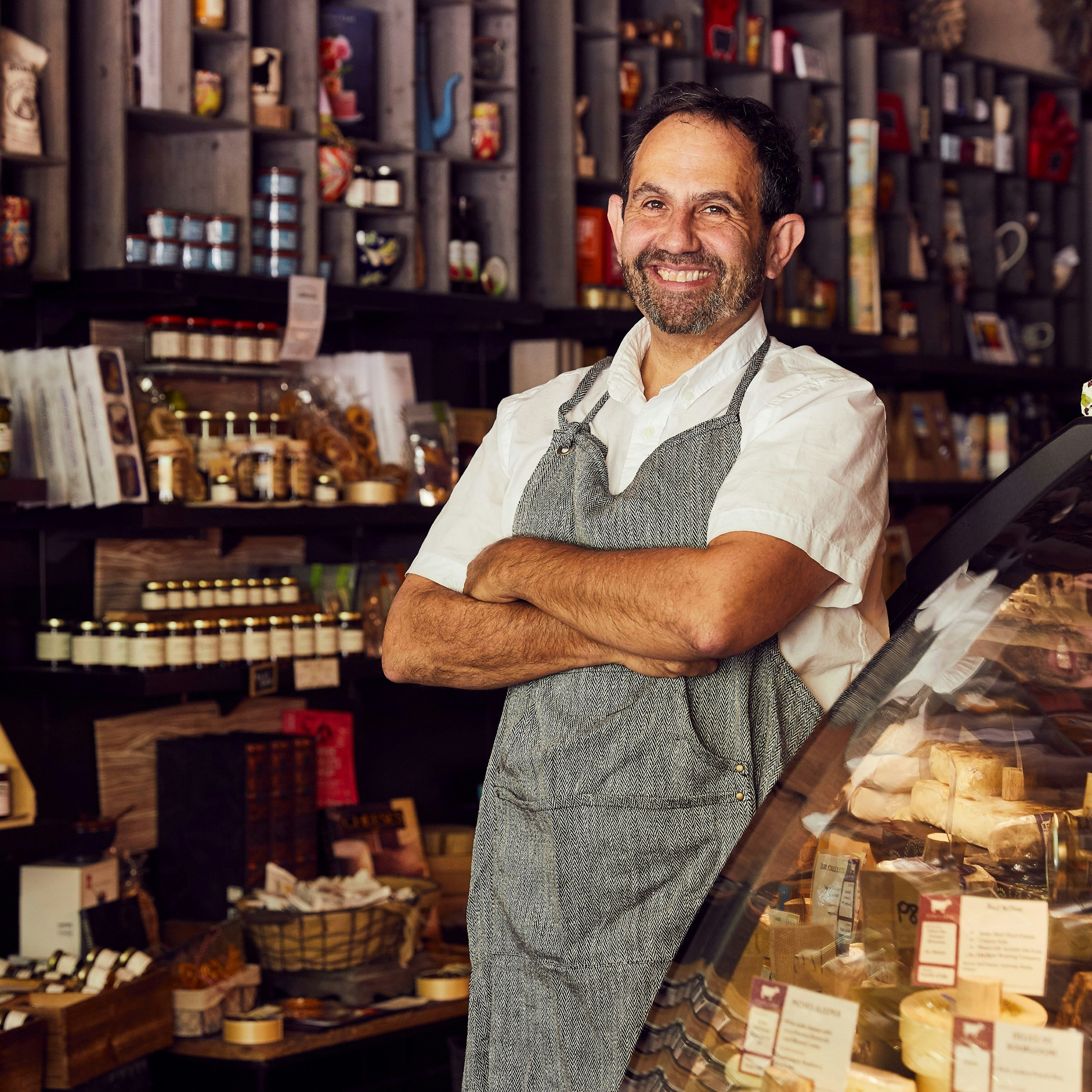 Ken Monteleone of Fromagination, surrounded by displays of cheese, jams and other artisanal products