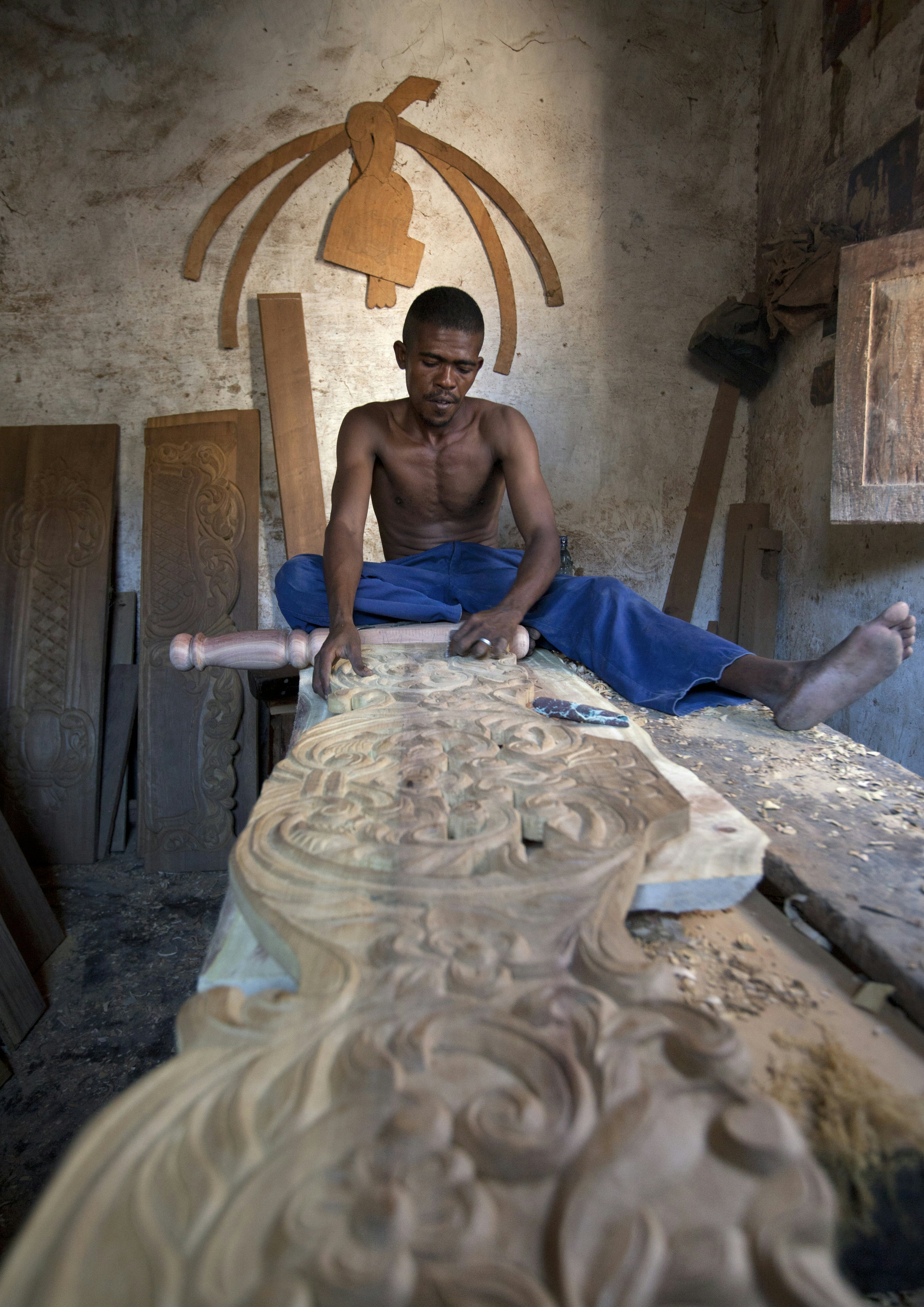 A woodworker carves furniture