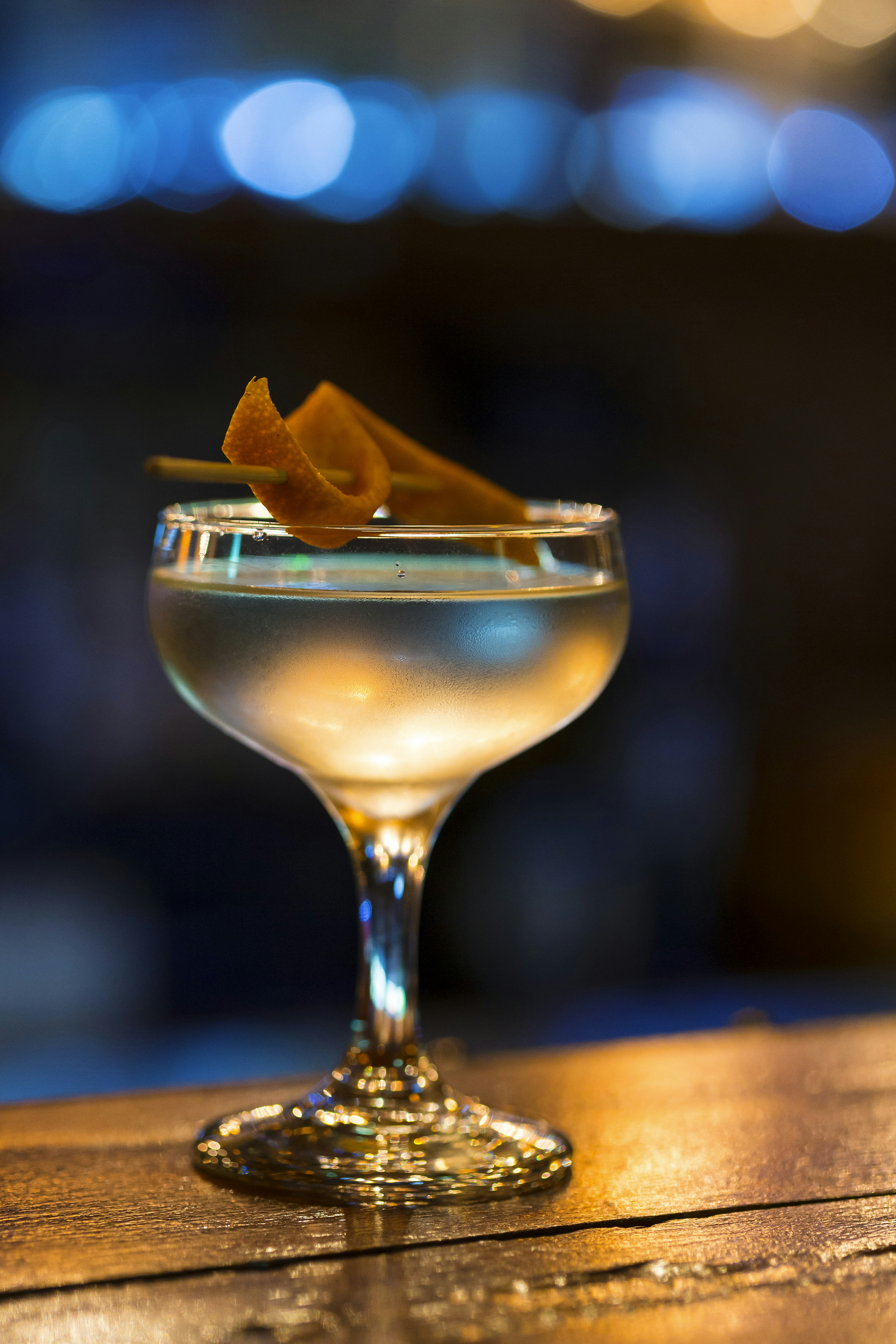 A tiny martini sits on a bar