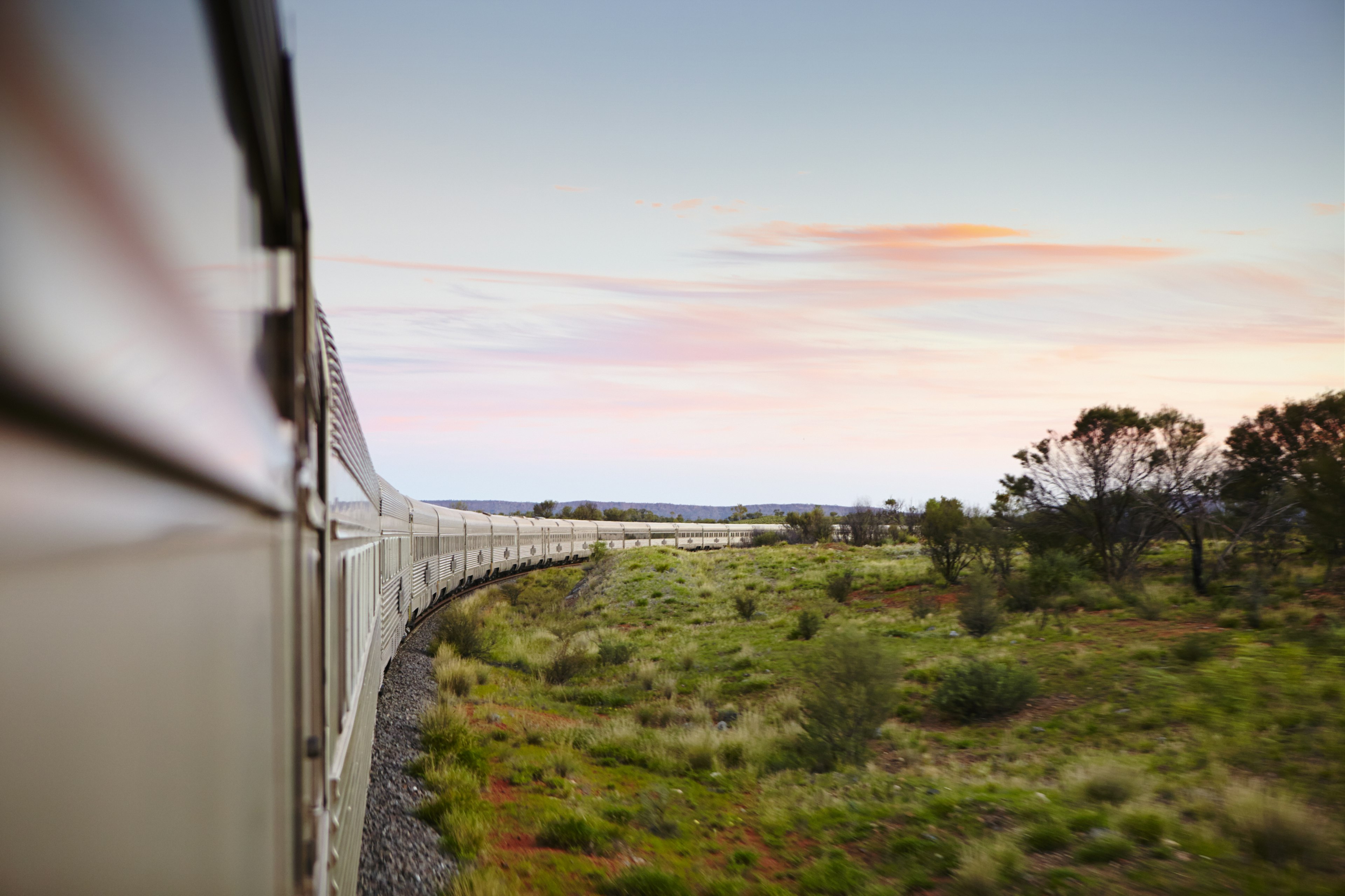 A train winds through an outback landscape in Australia.