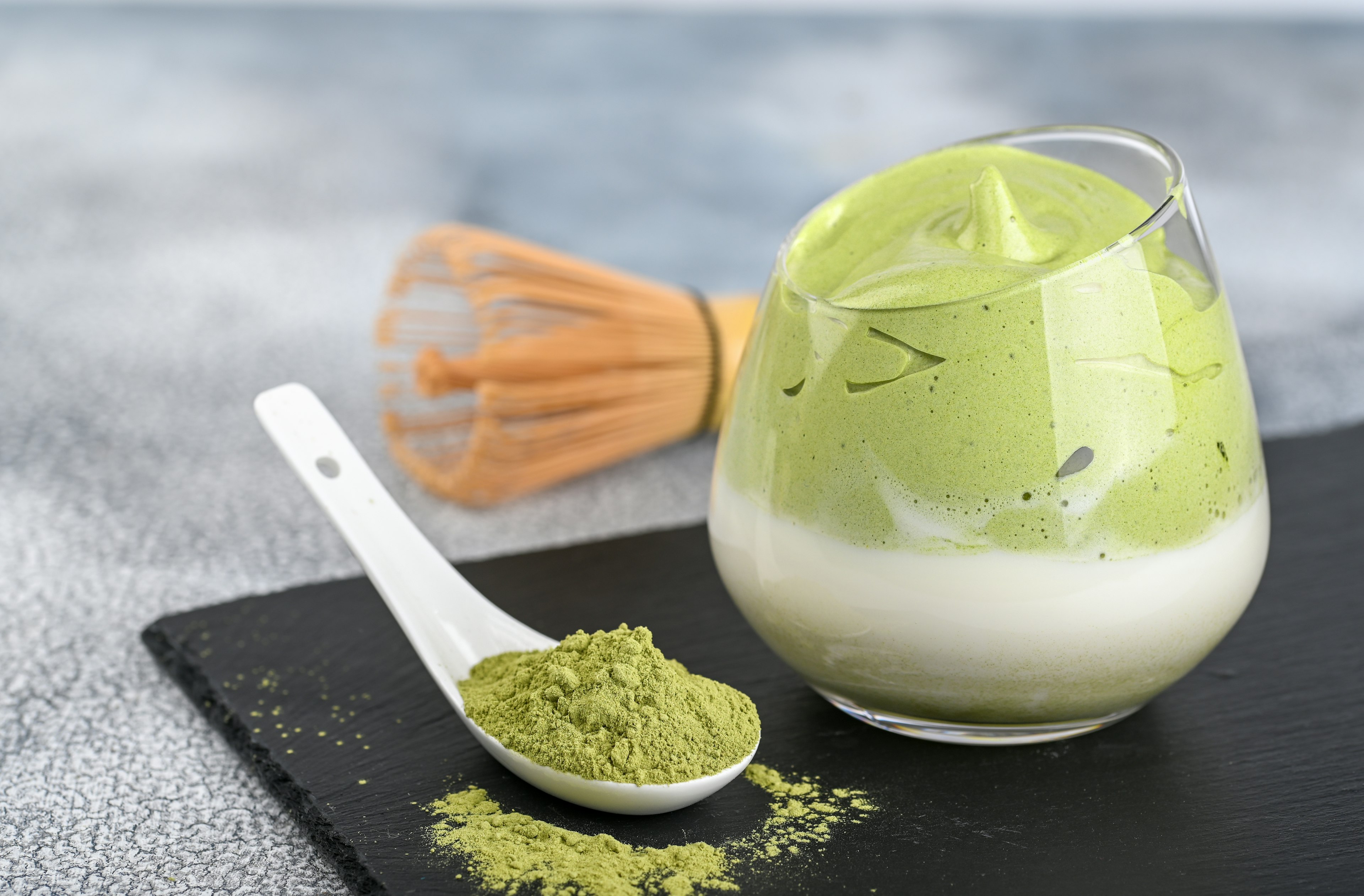 Dalgona Matcha Latte, a creamy whipped matcha, on light background. Matcha green tea.